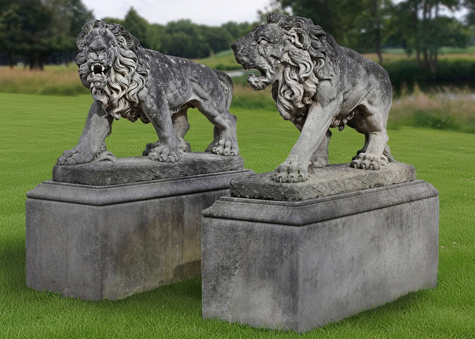 A PAIR OF MONUMENTAL SCULPTED LIMESTONE MODELS OF PROWLING LIONS, 20TH CENTURY: Portrayed opposing with jaws agape on rectangular bases, above rectangular pedestals. Height overall 182 cm. Height pedestals 72 cm. Length 186 cm. Width 70 cm.