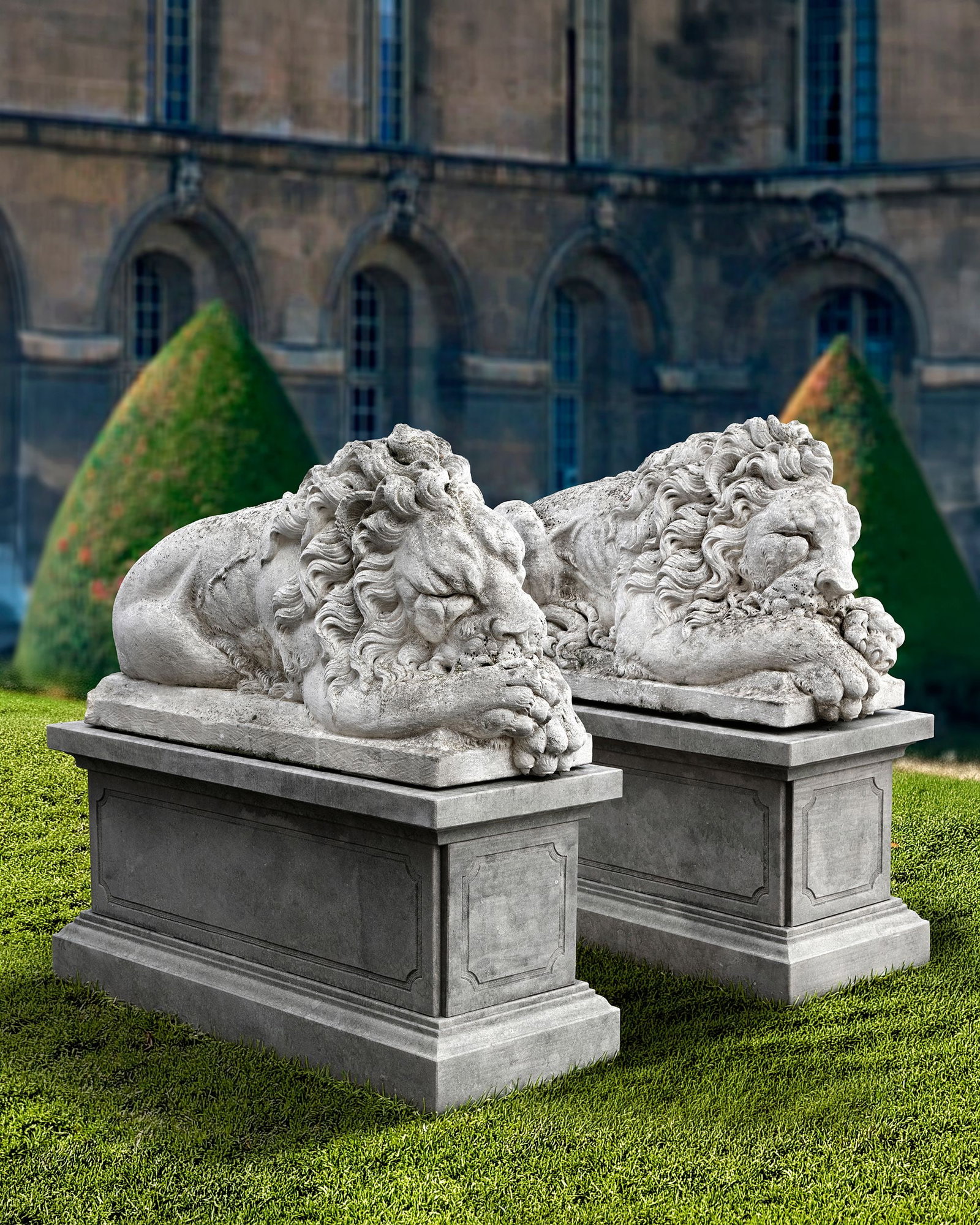 A PAIR OF SCULPTED LIMESTONE MODELS OF SLEEPING LIONS MID 20TH CENTURY, LOOSELY AFTER THE MANNER OF: Each typically portrayed with forepaw resting above the other, and with eyes closed, on integrally carved rectangular pedestals. Height each 78 cm. Atop later associated rectangular section pedestals,