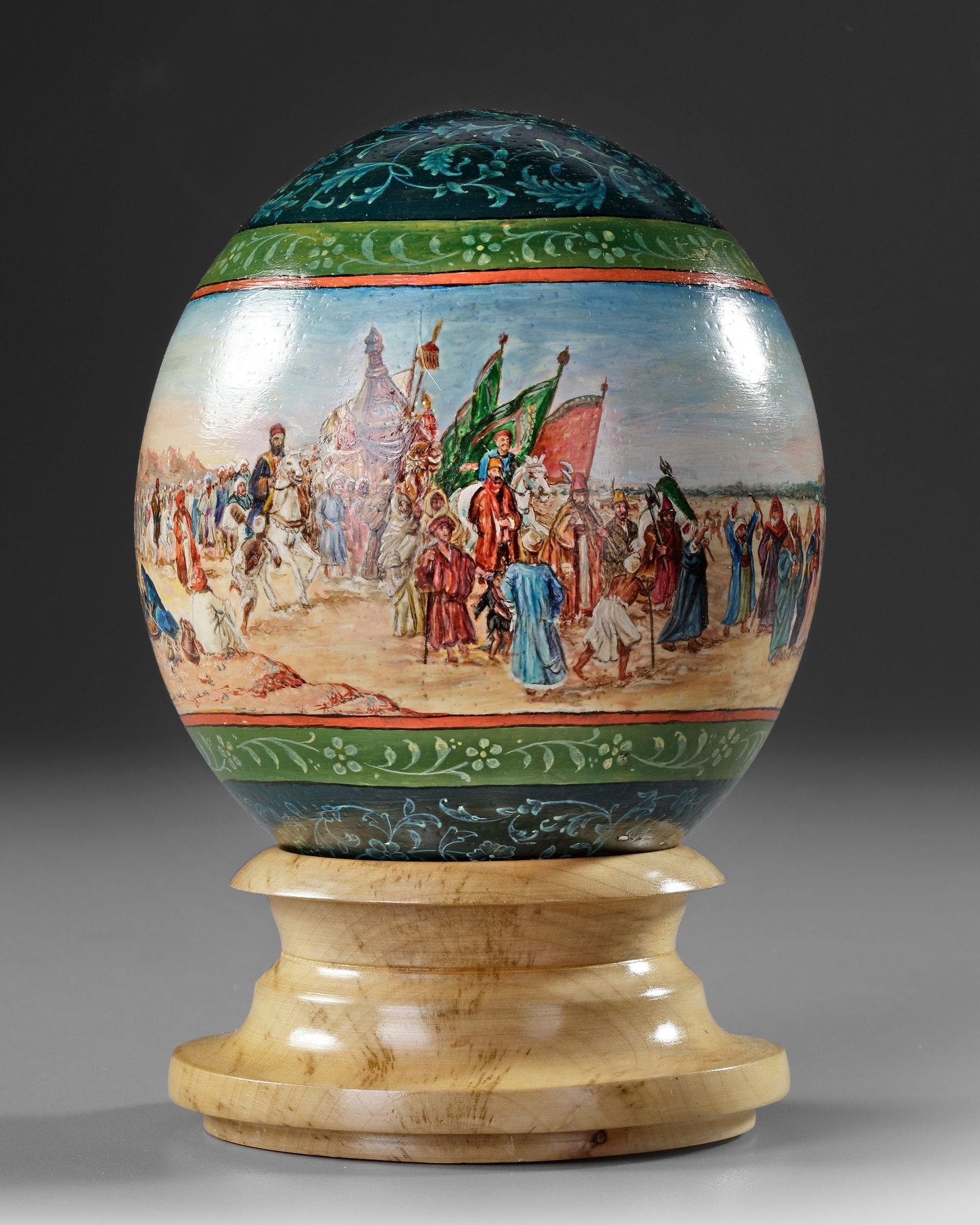 A PAINTED OSTRICH EGG, TURKEY, 20TH CENTURY: Elegantly painted in polychrome, the egg features a broad band encircling it, portraying a vivid scene of the Mahmalâ€™s journey to Mecca during the sacred Hajj pilgrimage. Height circa 21 cm.