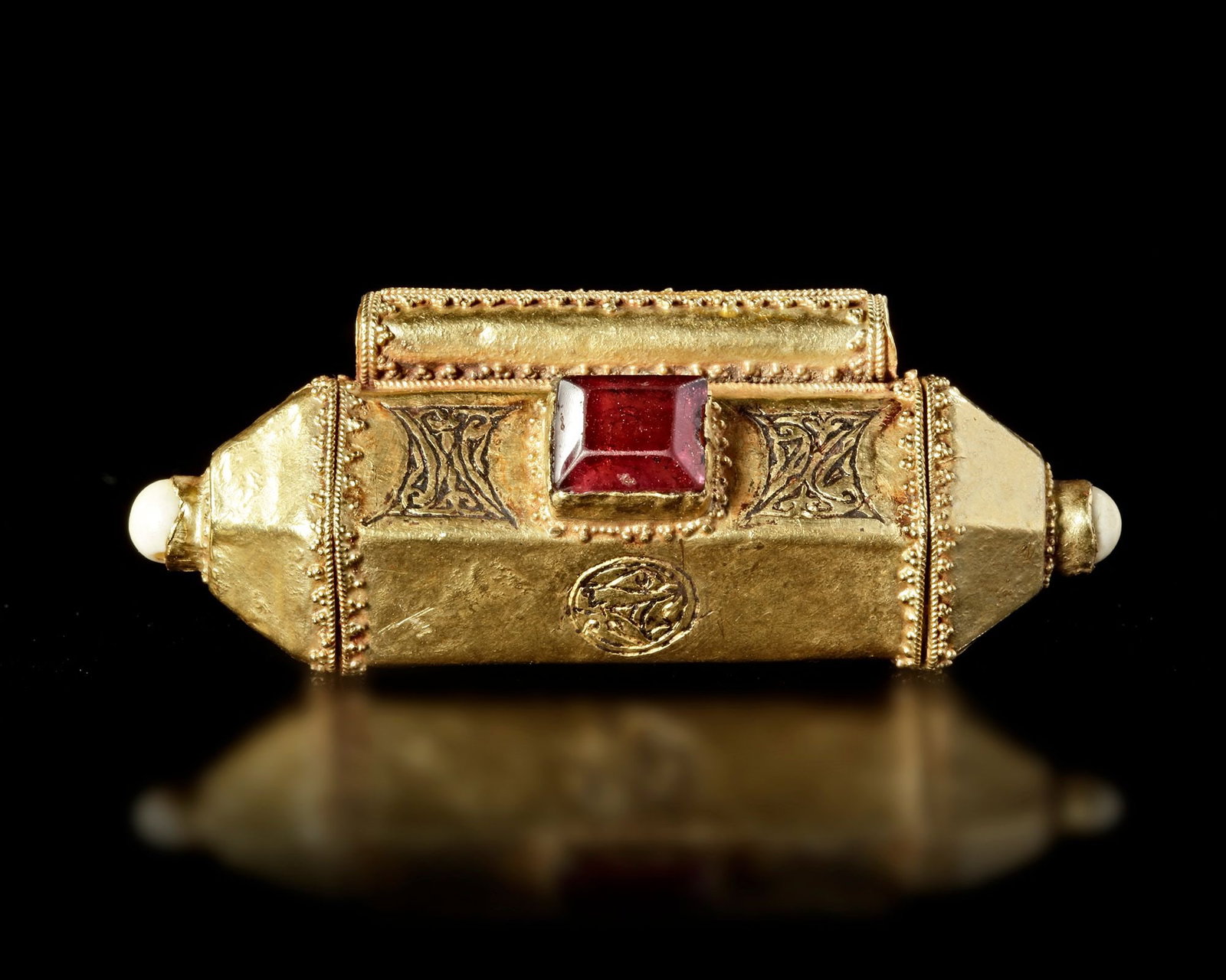 AN ISLAMIC GOLD TALISMAN HOLDER, SELJUK, 12TH-3TH CENTURY: A finely crafted Islamic talisman holder from the Seljuk period, made of gold and designed to contain protective prayers or sacred texts. The cylindrical case is decorated with engraved geometric moti