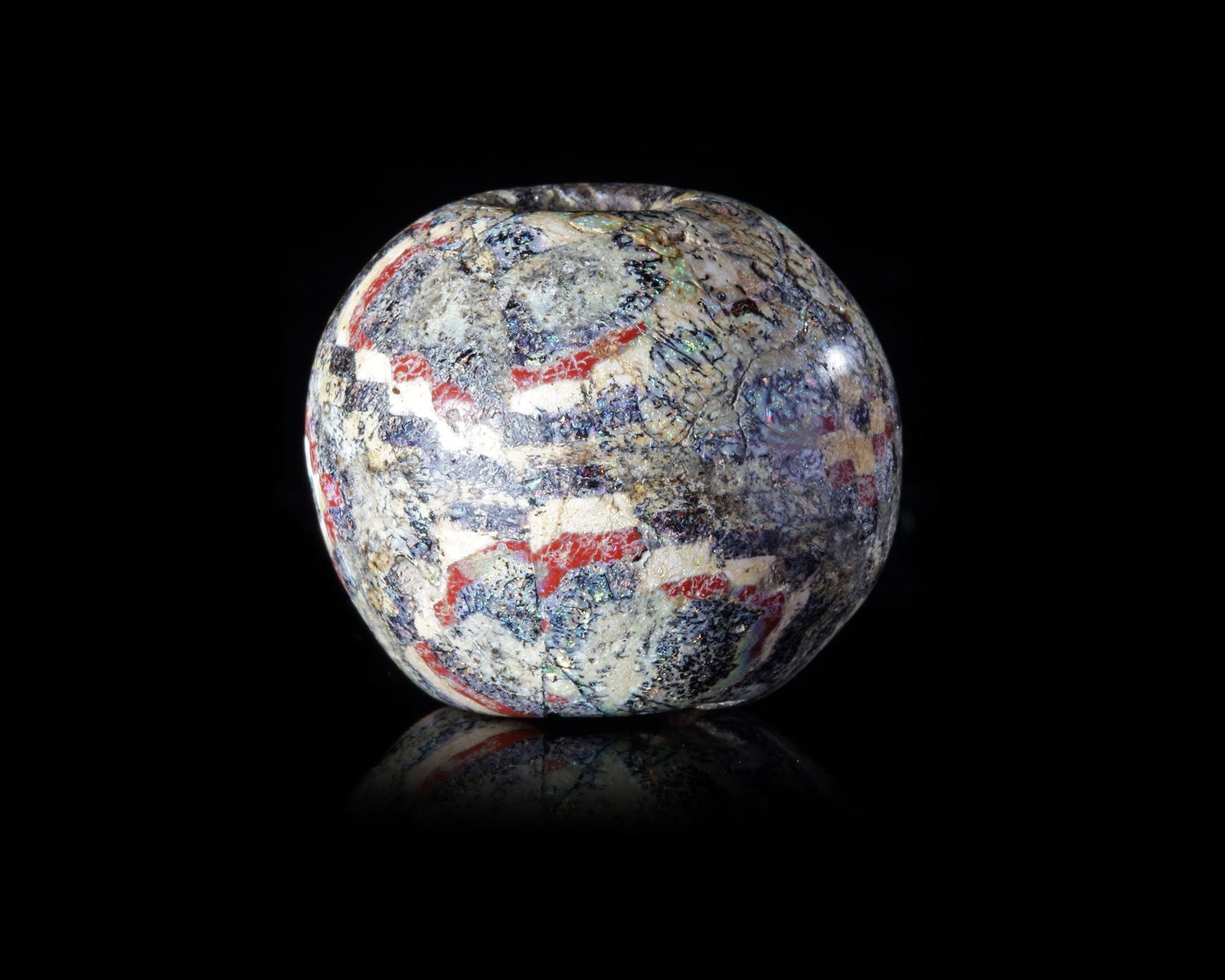 A LARGE SPHERICAL MOSAIC GLASS BEAD, ROMAN 1ST CENTURY AD: A large spherical Roman bead with geometric patterns. The origin of these glass paste beads seems to have been Egypt where a large industry in the material had flourished since Pharaonic times. The mo