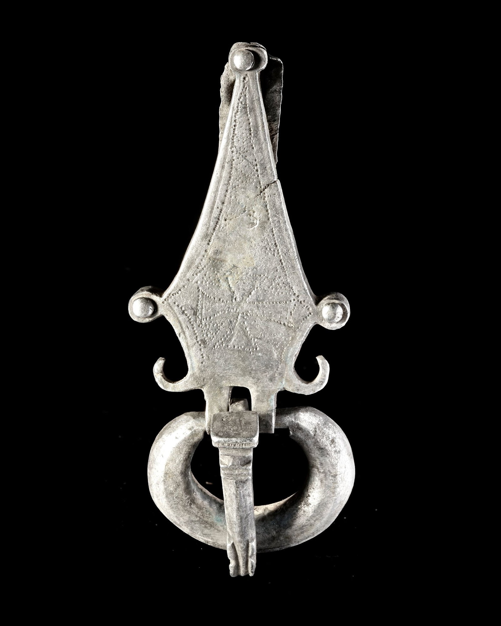 A BYZANTINE SILVER BUCKLE, 6TH CENTURY AD: A Byzantine silver buckle with an elegant back plate engraved with a cross. Three rivets attached the back plate to the belt. The tongue of the buckle has an animal motif at its finial. Silver Byzanti
