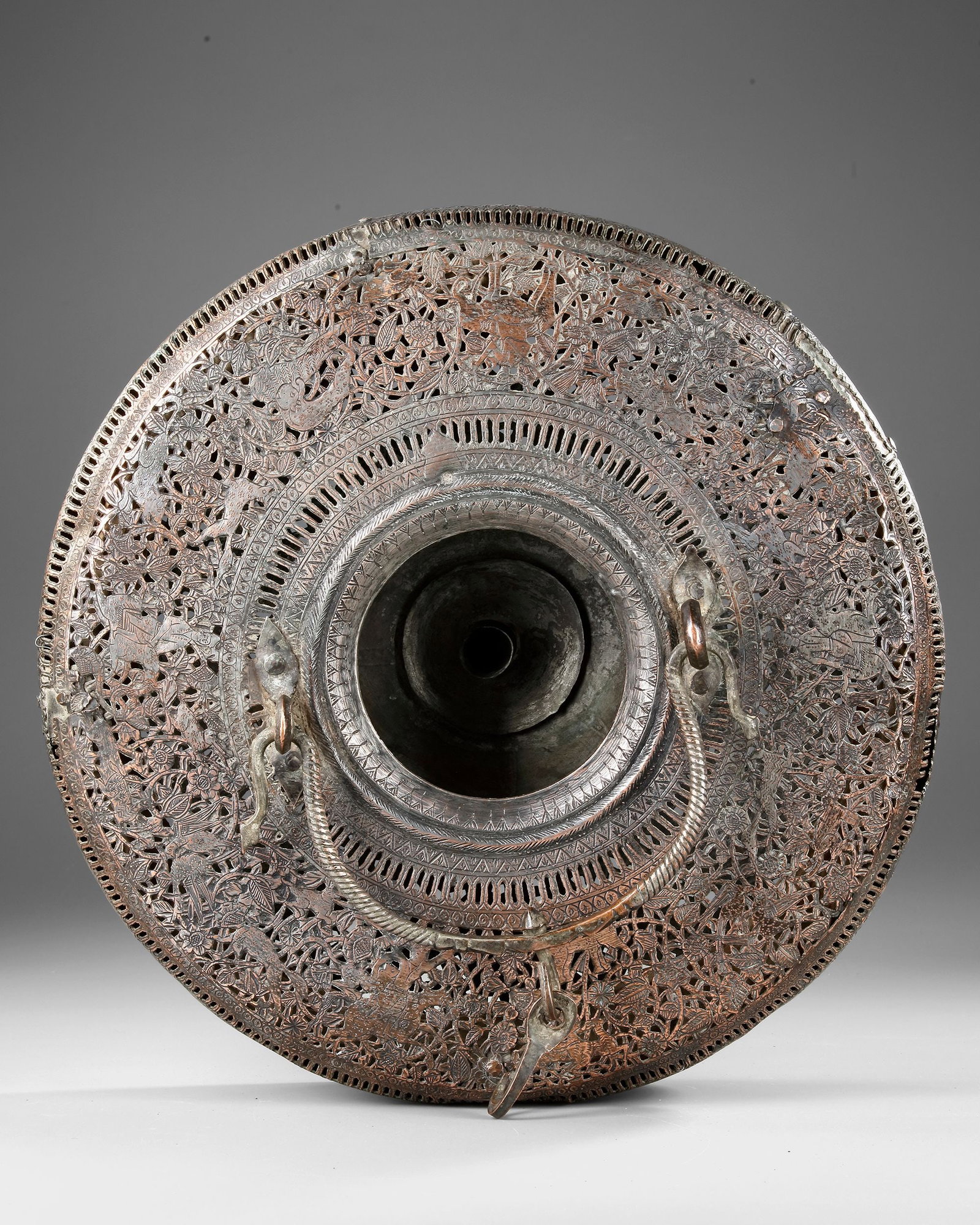 A QAJAR COPPER AND FOLDING PAPER LAMPION LANTERN, PERSIA, 19TH CENTURY: An elegant Qajar-period lantern crafted from tinned copper with intricate openwork decoration and a collapsible ribbed paper body. The pierced metal top and base display fine floral motifs, while the 