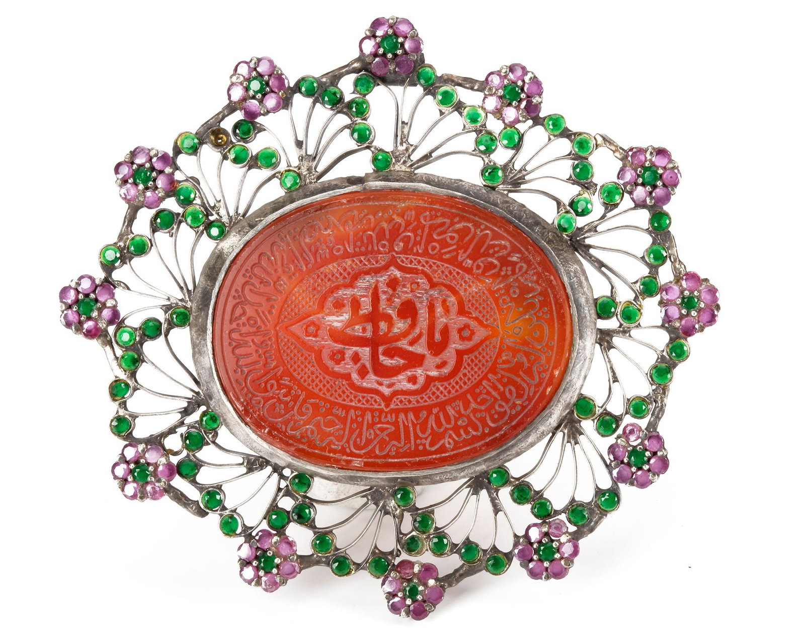 A MUGHAL GEM-SET CARNELIAN SILVER-MOUNTED PENDANT, INDIA, 19TH CENTURY: The carnelian, of oval form, is profusely engraved with a central medallion containing an inscription. The border features further bands of inscriptions, set in a silver mounting and adorned with gems