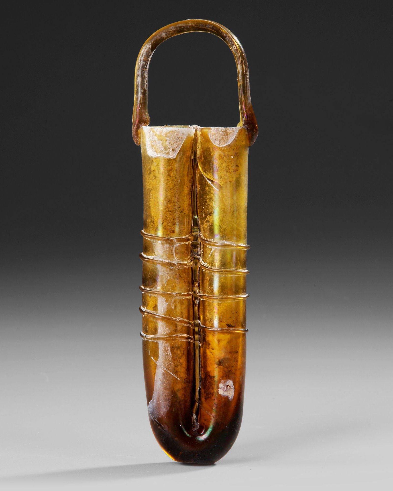 A DOUBLE-TUBE GLASS UNGUENTARIUM WITH APPLIED HANDLE, CIRCA 4TH-5TH CENTURY AD (1 of 3)