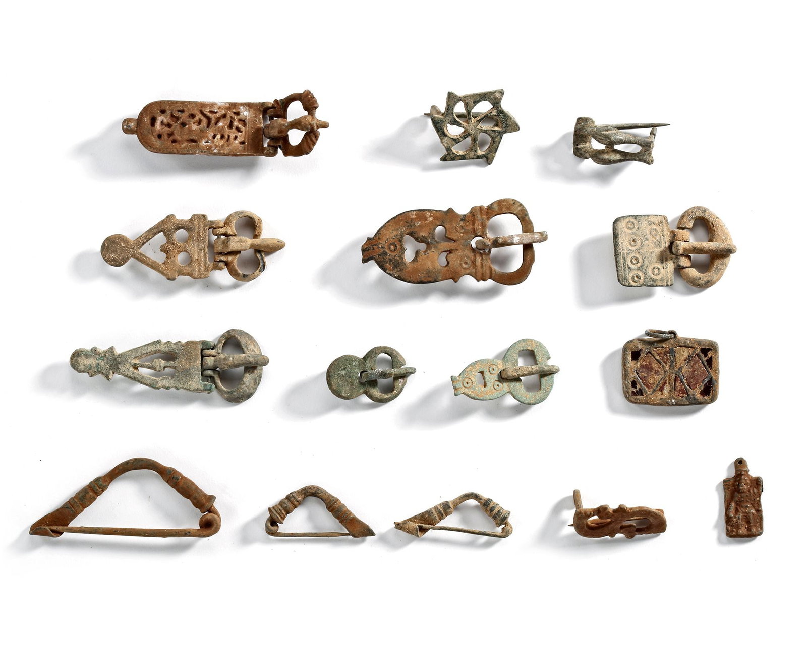 A SET OF ROMAN BUCKLES, 1ST-5TH CENTURY BC: A collection of Roman buckles of bronze and iron, with traces of enamel on some pieces, showcasing functional and decorative craftsmanship. Featuring intricate openwork patterns, geometric designs, an