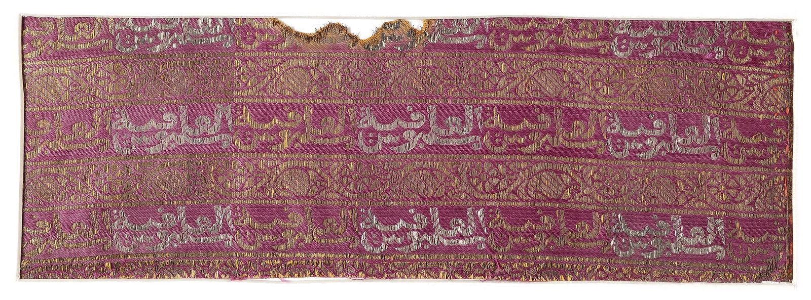 A RARE MUGHAL SILK LAMPAS FRAGMENT, 17TH CENTURY: The registers decorated with calligraphy, foliate designs interspersed with narrow registers of foliate designs picked out in gold thread. 23.5 by 8 cm. The inscriptions are a repetition of 'Malbus Al
