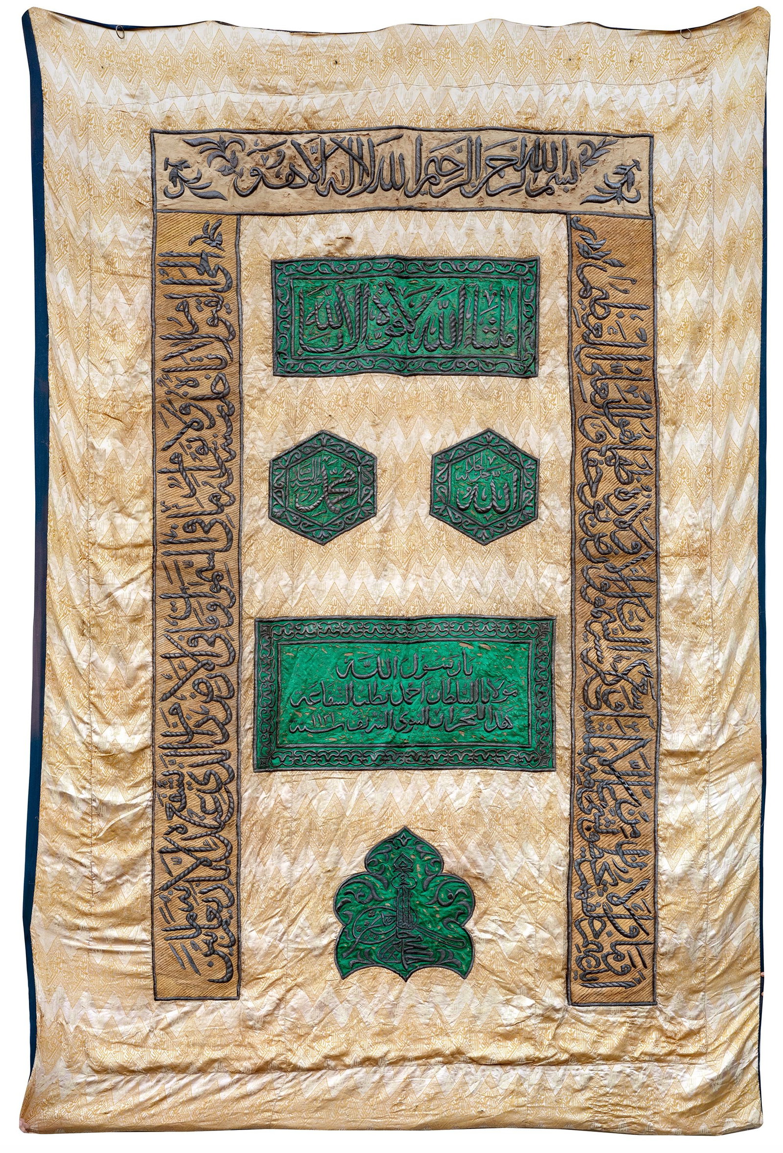 AN OTTOMAN SILK AND METAL-THREAD CURTAIN WITH THE TUGHRA OF SULTAN AHMAD, 1131 AH/1719 AD: Of rectangular form, embellished on a silk beige ground with a repeating of three undulating bands in gold script running from the beginning to the end of the cloth, which assume the form of a continu