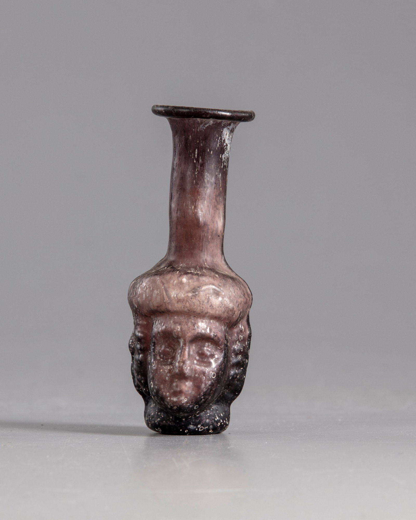 A ROMAN GLASS HEAD FLASK, CIRCA 3RD CENTURY AD (1 of 5)