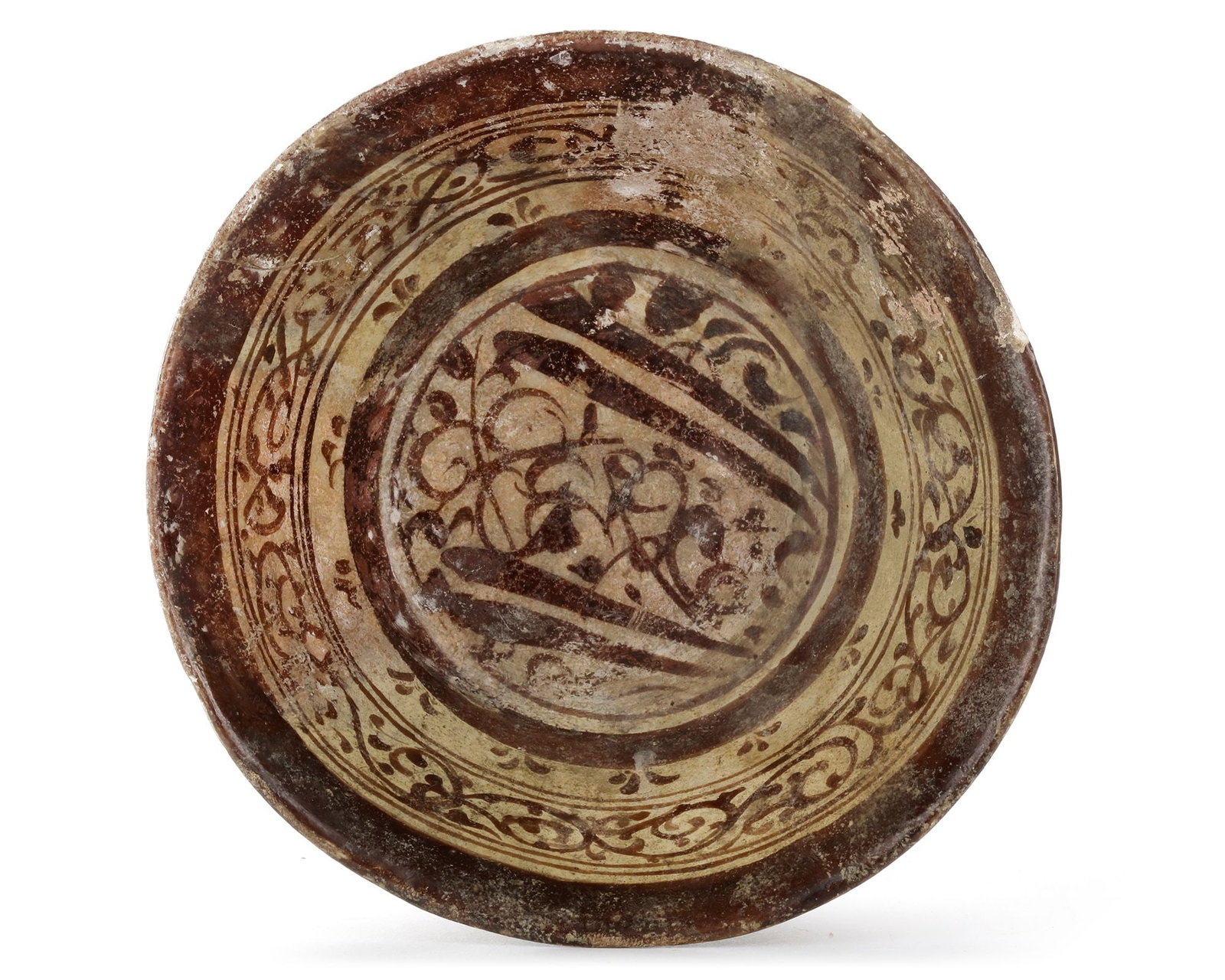 A KASHAN LUSTRE POTTERY BOWL, PERSIA, 12TH CENTURY: A Persian pottery bowl, resting on a small foot ring with a slightly flared rim, decorated to the centre and the sides with floral motifs and scrolls. 12.5 by 6 cm.
