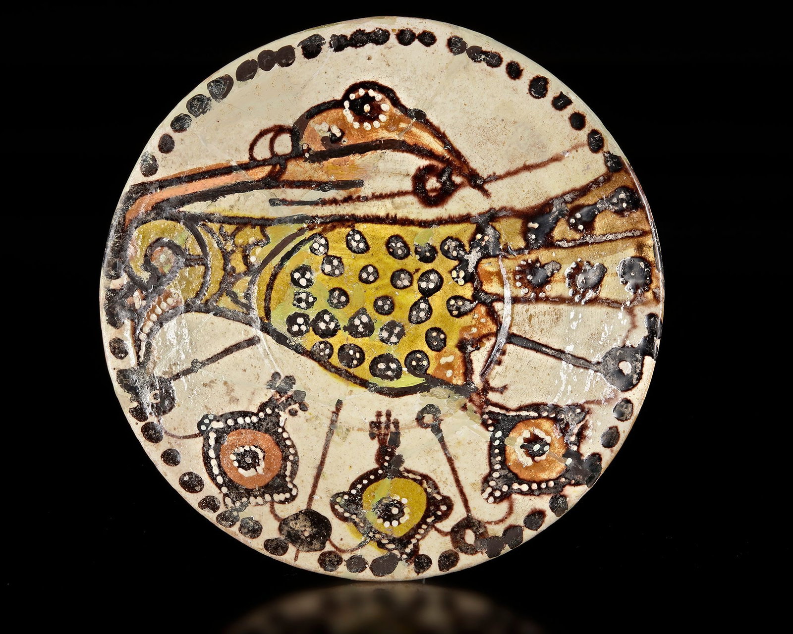 A NISHAPUR POTTERY BOWL WITH BIRD, PERSIA, 10TH CENTURY: Of deep form, this earthenware bowl is coated with a white slip and decorated in black, red, and yellow staining slips beneath a transparent glaze. The interior features a large, stylized peacock with