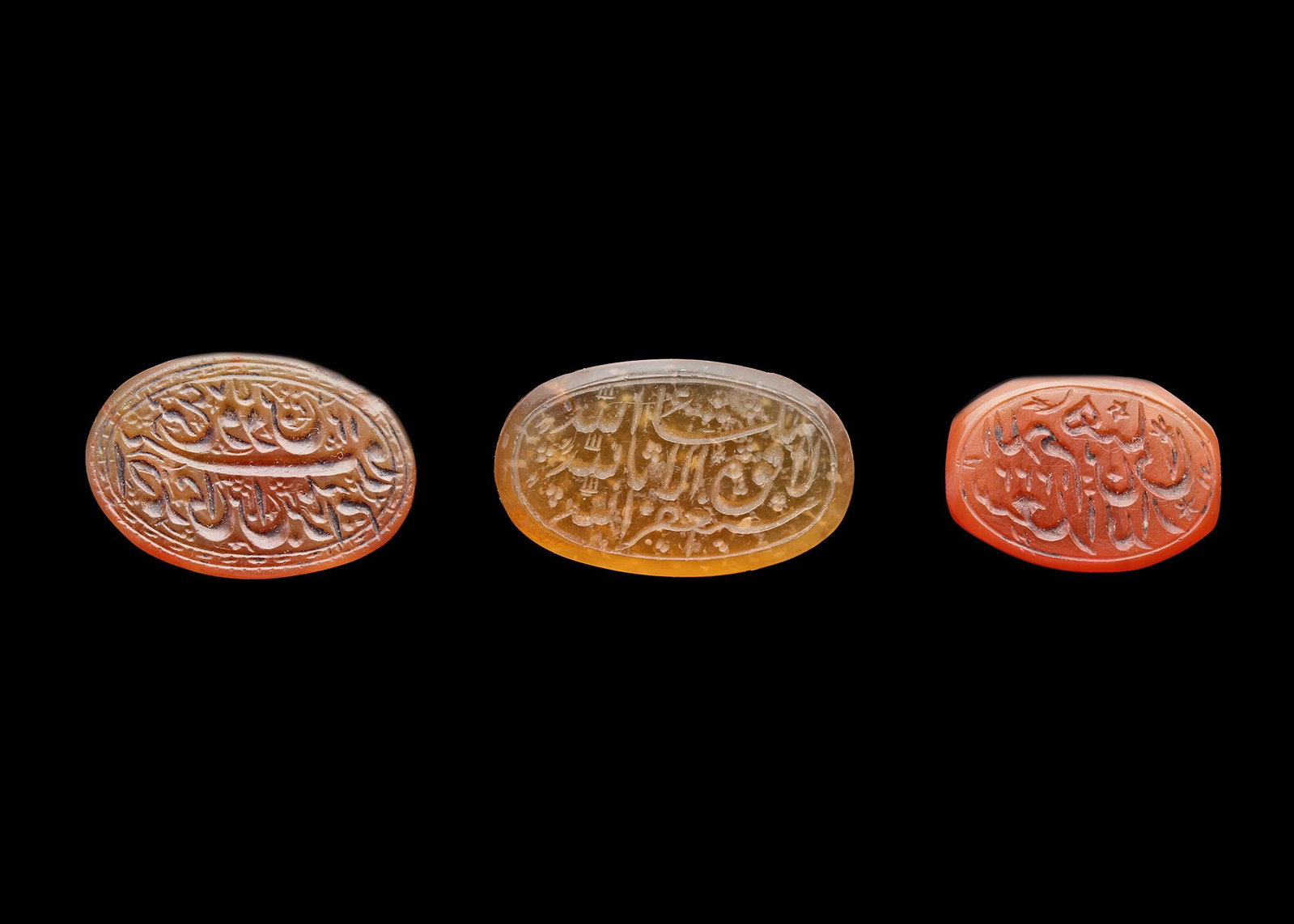 THREE PERSIAN AGATE SEALS, QAJAR PERIOD,18TH-19TH CENTURY: A Qajar agate seal of rounded form, light brown in colour, engraved in nastaliq script with " ?´?±?? ?????Š?† ???­?…???Š ?¨?† ?§?¨?±?§?‡?Š?…, law and religion Ahmadi Bin Ibrahim",