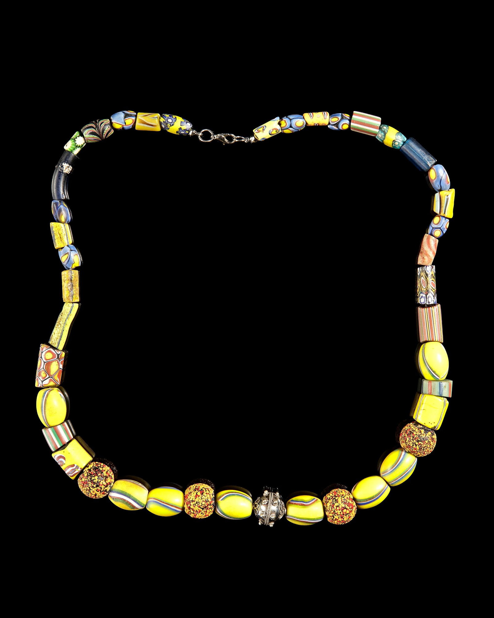 A MULTI-COLOR GLASS TRADE BEAD NECKLACE: Elegant handcrafted necklace featuring 42 assorted glass beads in vibrant yellow, blue, green, red, and black tones. A striking mix of striped, millefiori-inspired, and decorative trade beads creates 