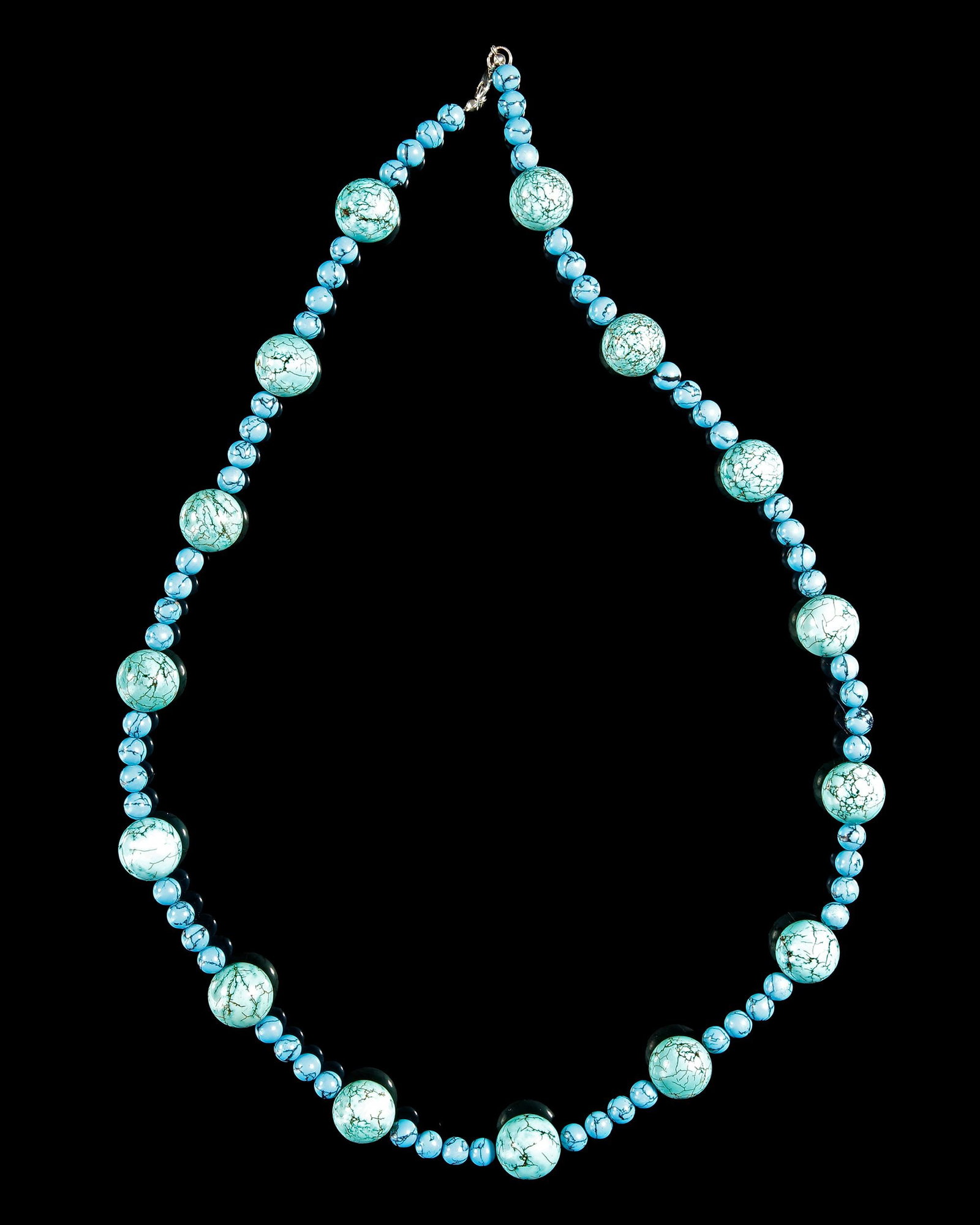 A TURQUOISE BEADED NECKLACE: Elegant handcrafted turquoise necklace featuring 64 small beads and 15 larger accent beads. Beautifully balanced with vibrant blue tones and natural veining, this timeless piece adds a refined touch t