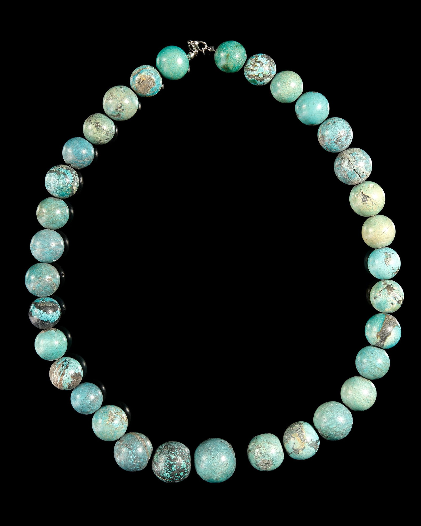 A TURQUOISE BEADED NECKLACE: Elegant handcrafted necklace featuring 33 polished turquoise beads with natural blue-green hues and distinctive matrix patterns. The graduated design highlights the unique beauty of each bead, creatin