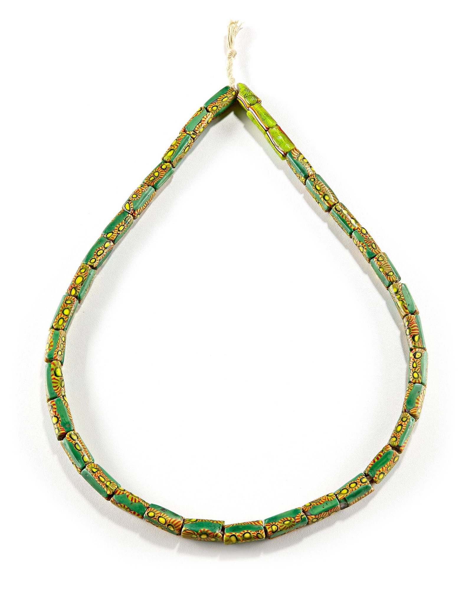 A VENETIAN-STYLE MILLEFIORI GLASS BEAD NECKLACE: A vibrant necklace composed of elongated Venetian-style millefiori mosaic glass beads in shades of green, yellow, red, and black. Each bead displays repeating floral and sunburst cane motifs, creating