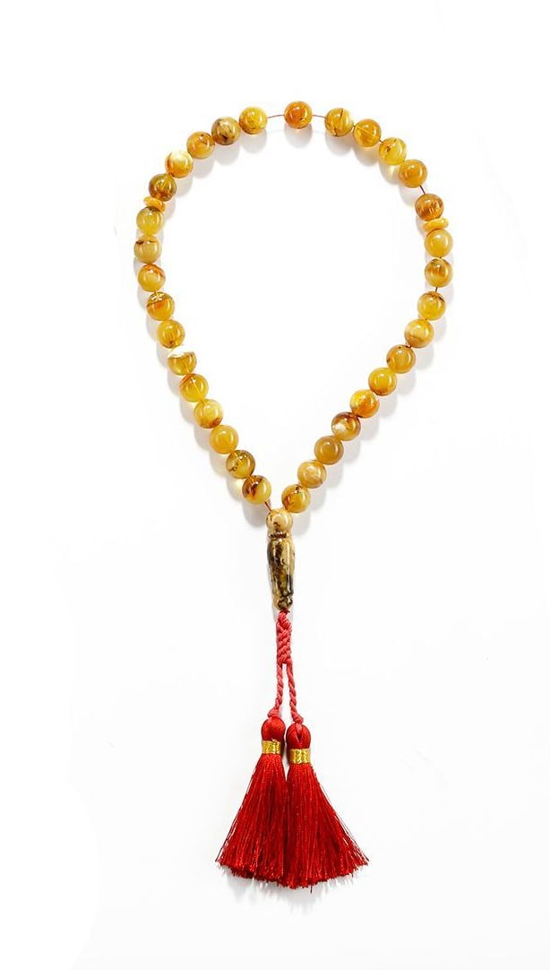 AN AMBER-COLORED TASBIH (MISBAHA): Beautiful 33-beads tasbih featuring smooth, polished amber-colored round beads and two spacer beads for comfortable counting during dhikr. The tasbih is finished with a decorative imame (handle) and t