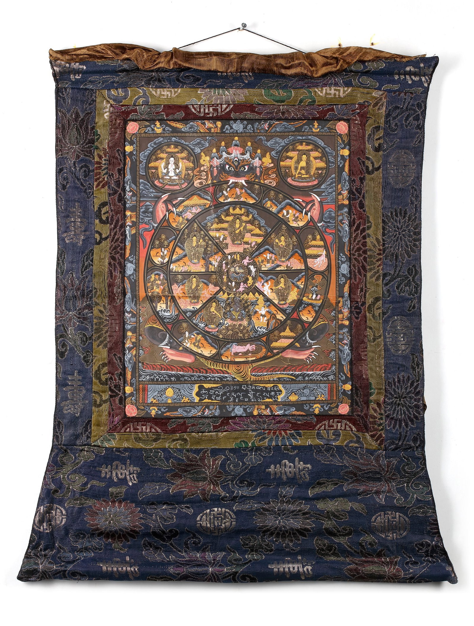 A WRATHFUL DEITY MANDALA THANGKA, TIBET, 20TH CENTURY: A finely detailed Tibetan thangka depicting a sacred mandala centered on a wrathful protective deity, surrounded by celestial Buddhas, enlightened beings, and symbolic realms. Richly painted in vibran