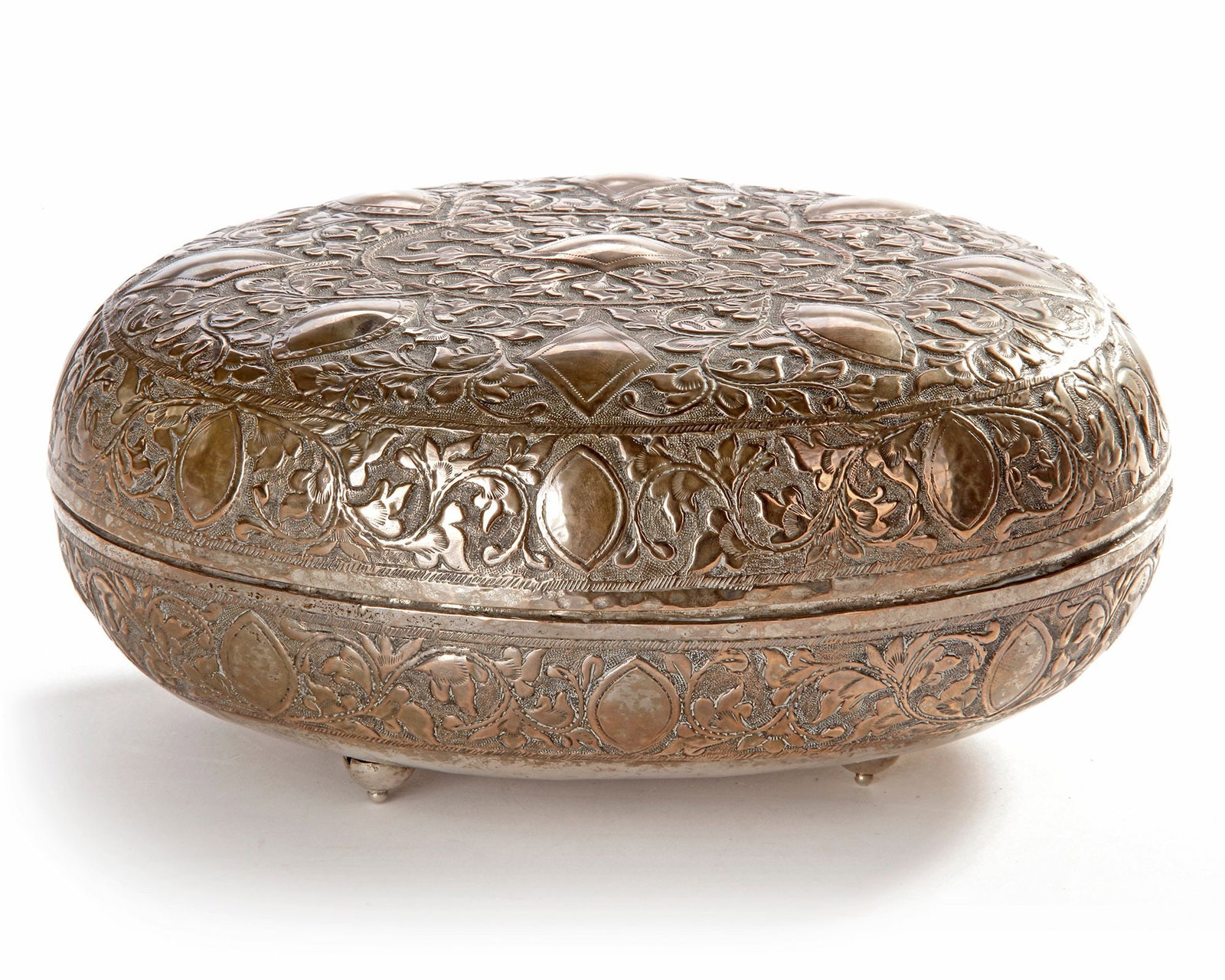 A MALAY SILVER BOX WITH COVER, 19TH CENTURY: Richly decorated in repouss?© floral and geometric designs, resting on small rounded feet. 19 by 15 cm. 202 gr. THE DR. SAAD AL-JADIR COLLECTION