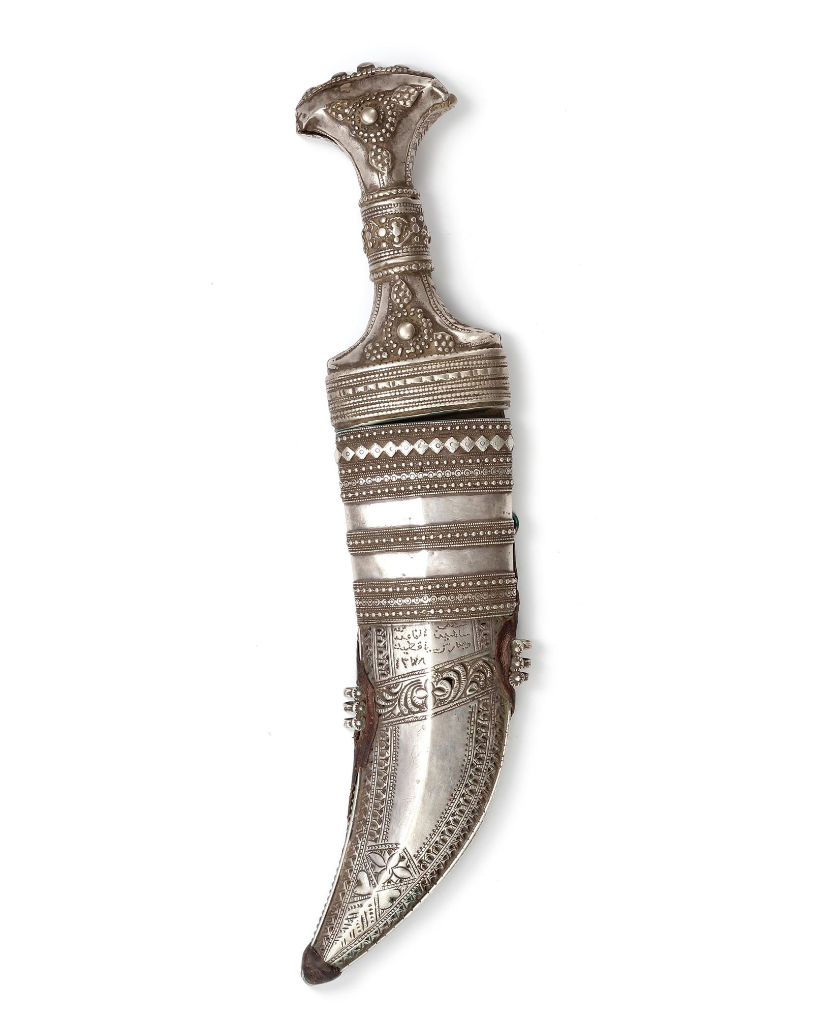 A SILVER DAGGER, YEMEN, EARLY 20TH CENTURY: An early 20th-century Yemeni silver dagger (janbiya) with a curved steel blade and richly decorated silver hilt and scabbard, adorned with intricate geometric and floral motifs, as well as Arabic insc