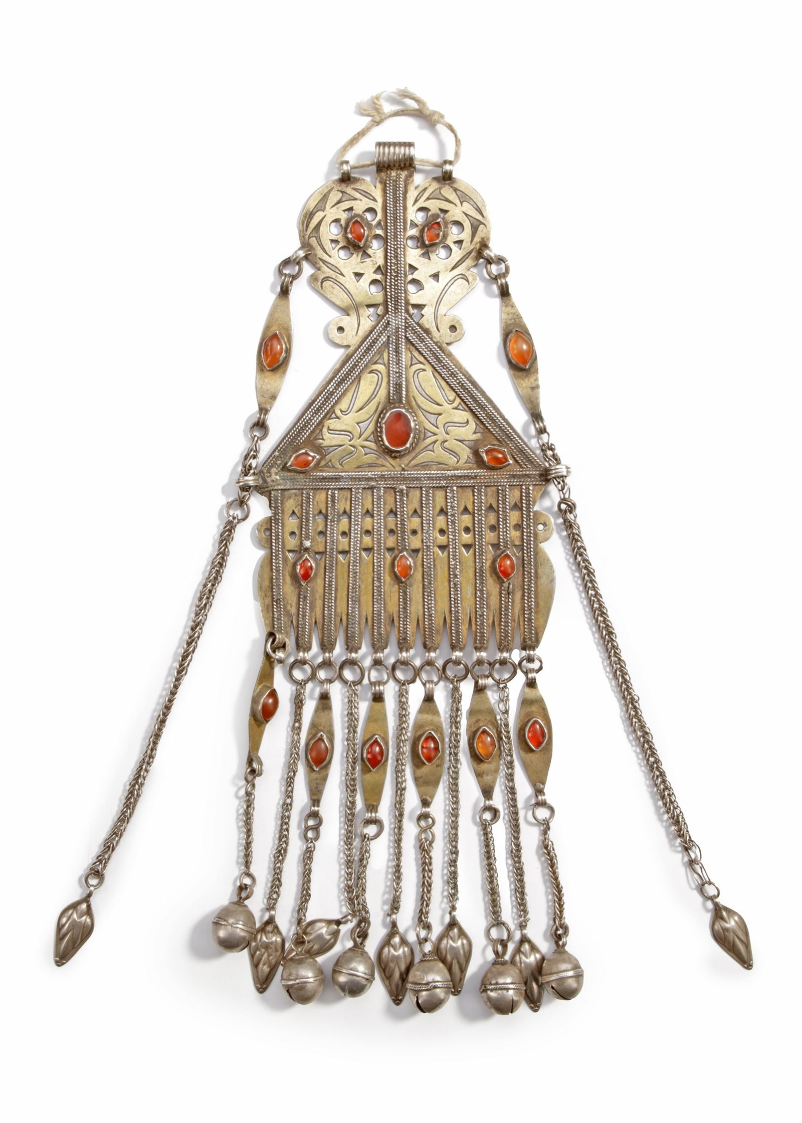 A SILVER PENDANT, TURKMENISTAN, 19TH CENTURY: Decorated with engraved patterns, gilded details, and inset carnelians. The triangular form is enriched with dangling chains, bells, and amulets. 28 by 10 cm. 220 gr. THE DR. SAAD AL-JADIR COLLECTION
