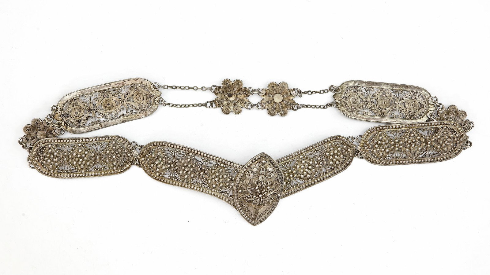 AN OTTOMAN SILVER BELT, 19TH CENTURY: Composed of intricately pierced floral panels linked together. The central clasp features a rosette design. 72 cm. 190 gr. THE DR. SAAD AL-JADIR COLLECTION