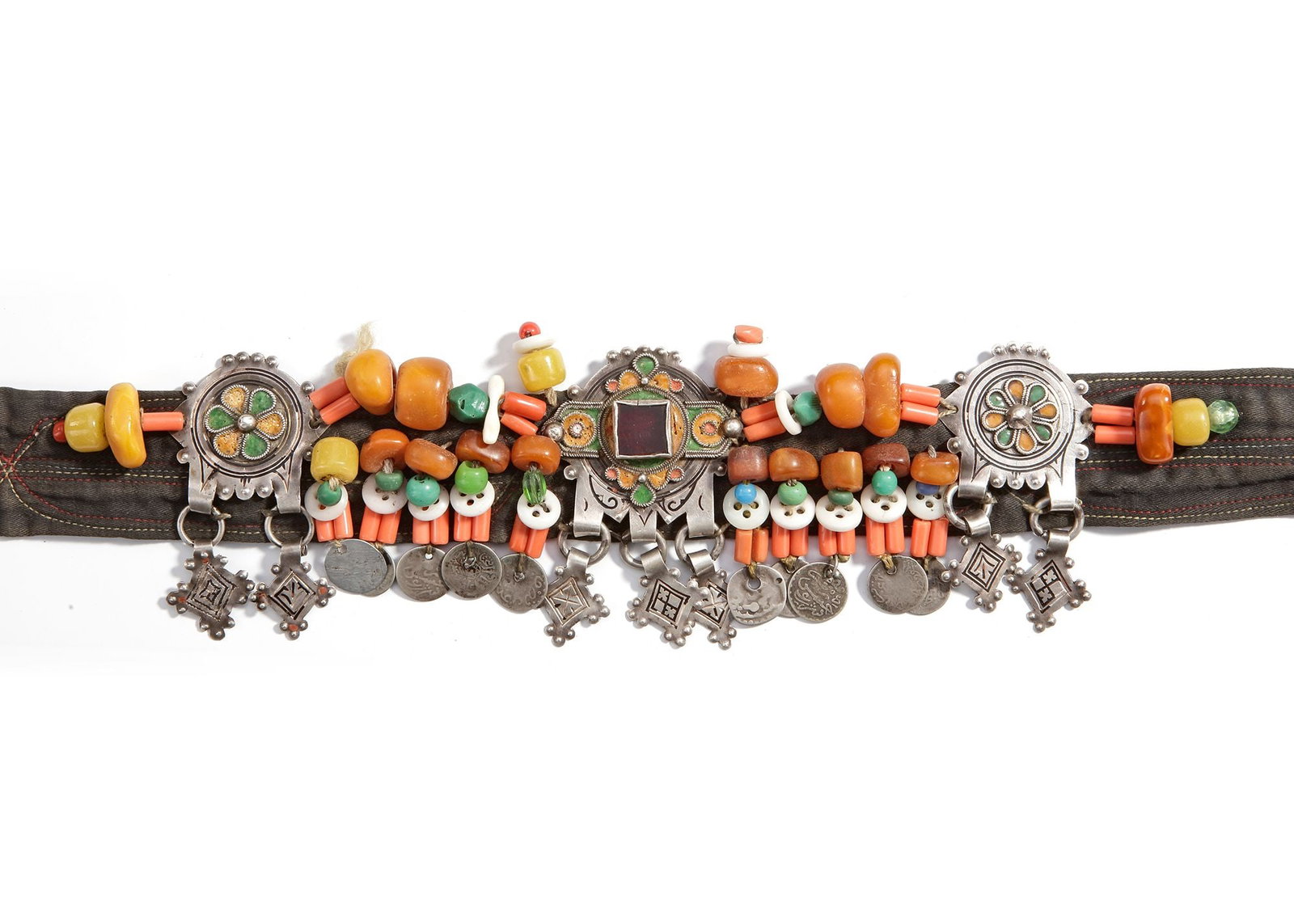 A SILVER BELT, SOUTH MOROCCO, 20TH CENTURY: Richly adorned with amber beads, coral, glass, and enamel plaques. The central silver elements feature geometric and floral enamel designs, flanked by strings of old coins and colorful beads. 28 cm. 1