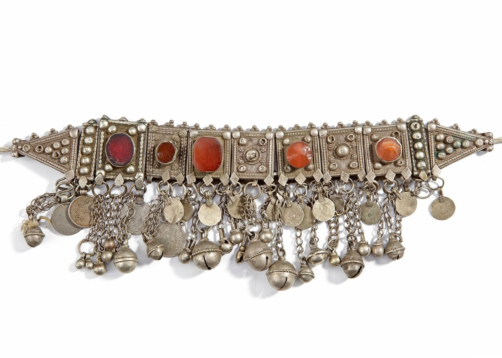 A SILVER NECKLACE, YEMEN, 19TH CENTURY: Traditional Yemeni necklace with carnelian stones, coin pendants, and dangling bells, richly crafted in silver. 31 by 10 cm. 222 gr. THE DR. SAAD AL-JADIR COLLECTION