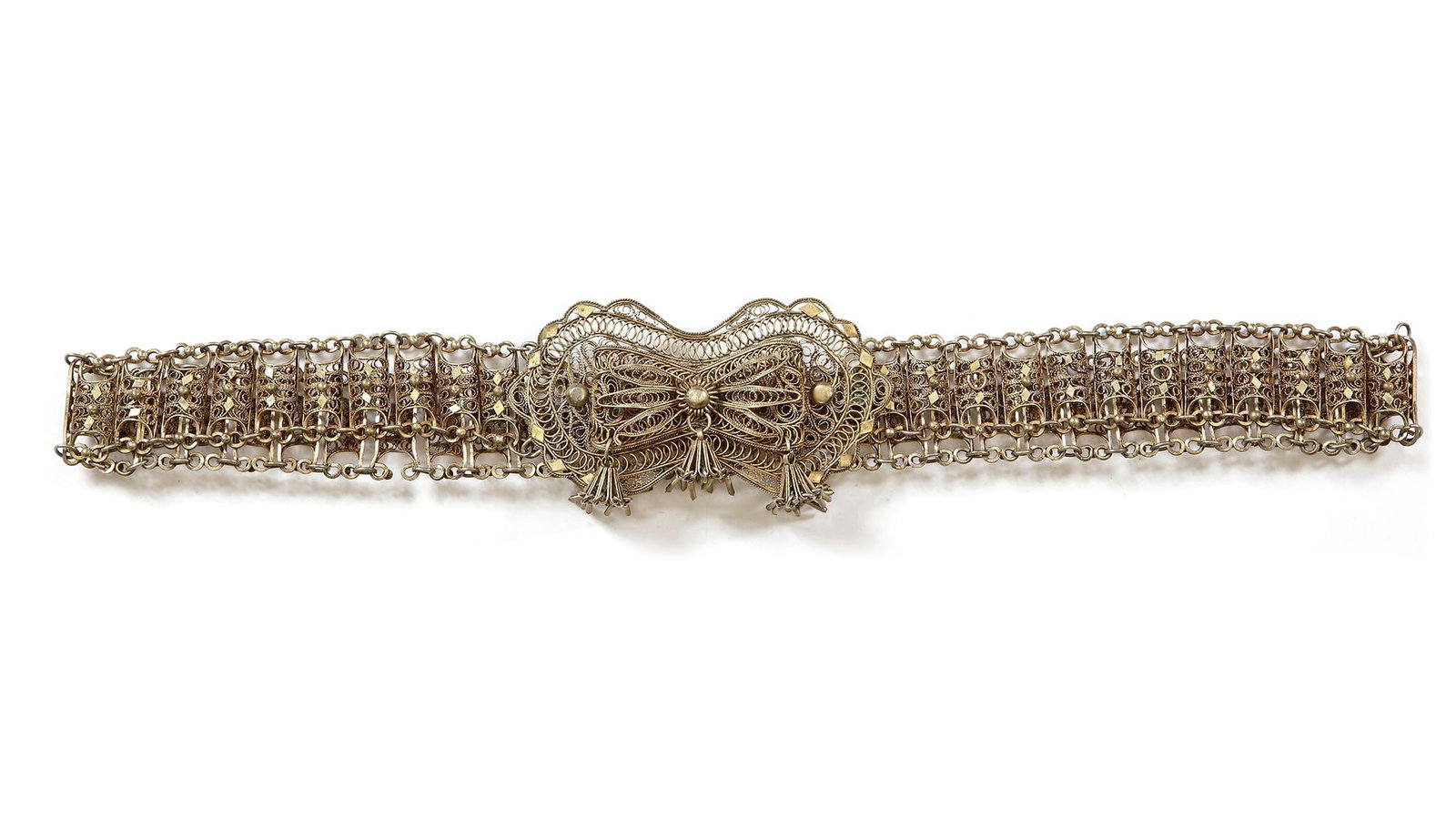 AN OTTOMAN SILVER BELT, 19TH CENTURY: With intricate filigree work and a large ornate clasp with tassel details. 80 by 4 cm. 181 gr. THE DR. SAAD AL-JADIR COLLECTION