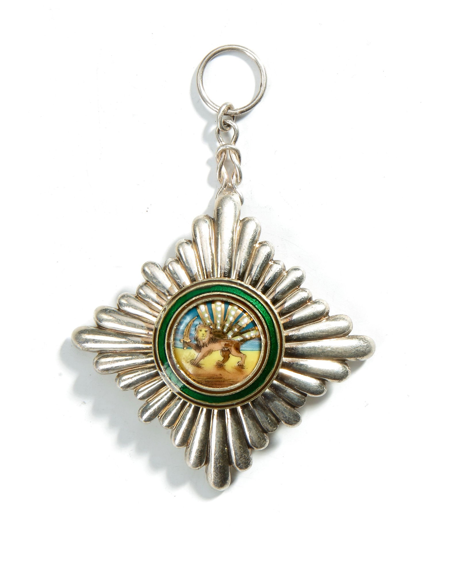 A PERSIAN SILVER AND ENAMEL MEDALLION, EARLY 20TH CENTURY: A fine Persian medallion featuring a radiant sunburst design with central enamel decoration of the Lion and Sun motif, symbol of Qajar Iran. Surrounded by green enamel ring and silver rays, with suspe