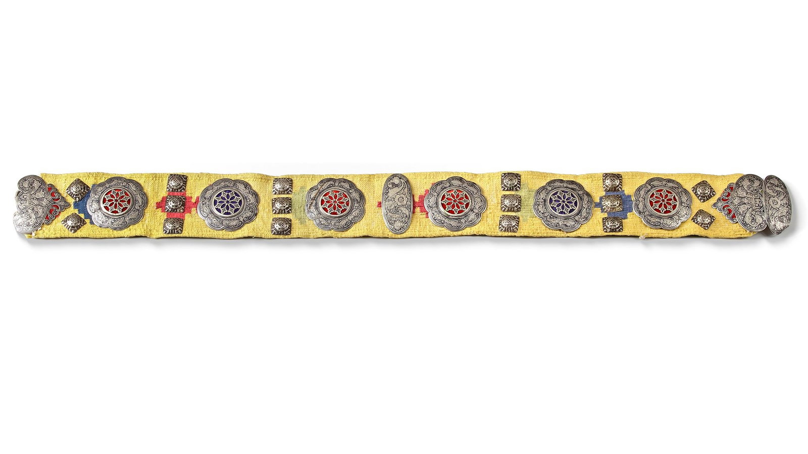 A CAUCASIAN NIELLO SILVER BELT, 19TH CENTURY: A finely crafted 19th-century Caucasian belt featuring niello silver plaques with intricate floral and geometric designs. Mounted on a yellow textile base, it displays alternating red and blue enamel 