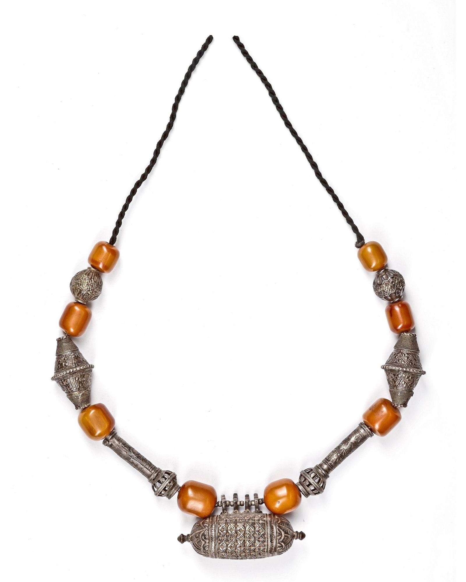 A YEMENI NECKLACE, 19TH CENTURY: With large honey-colored beads combined with finely crafted silver elements. The central pendant showcases intricate geometric patterns. 25 by 9 cm. 164 gr. THE DR. SAAD AL-JADIR COLLECTION