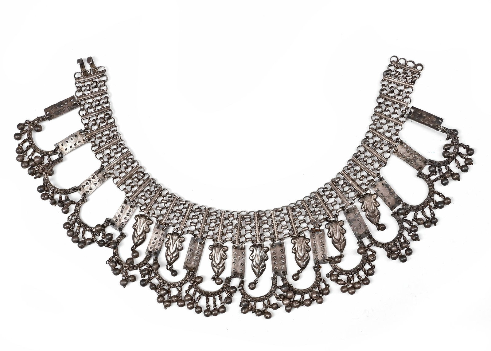 AN AFGHAN SILVER NECKLACE, 19TH CENTURY: Silver necklace featuring intricate openwork links and multiple dangling pendants with floral motifs. The lower edge is richly adorned with clusters of small silver beads. 37 by 8 cm. 174 gr. THE DR. 