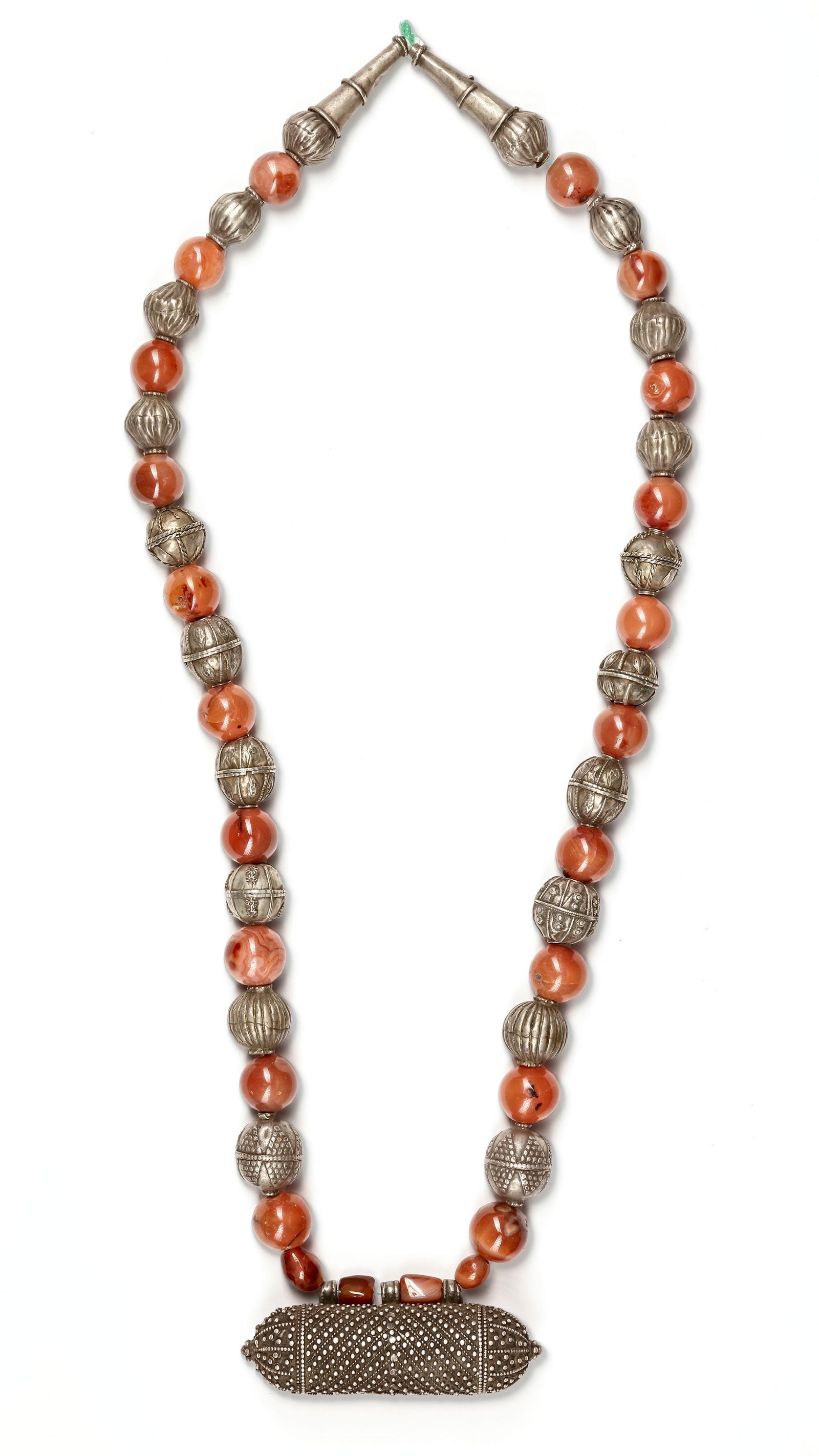 A SILVER NECKLACE, YEMEN, 19TH CENTURY: An elegant Yemeni necklace composed of alternating polished agate beads and finely crafted silver spheres with detailed engravings. The centerpiece is an elongated silver amulet case (hirz) decorated 