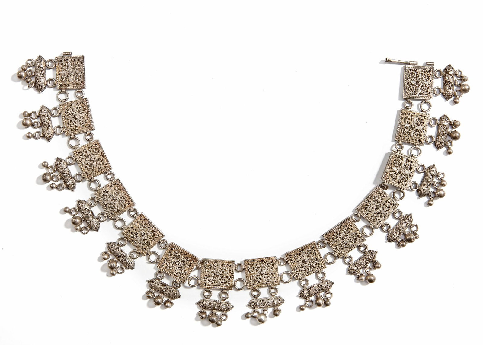 A SILVER NECKLACE, YEMEN, 19TH CENTURY: Traditional Yemeni necklace with square filigree panels and dangling ornaments, finely handcrafted in silver. ca. 40 cm. 125 gr. THE DR. SAAD AL-JADIR COLLECTION