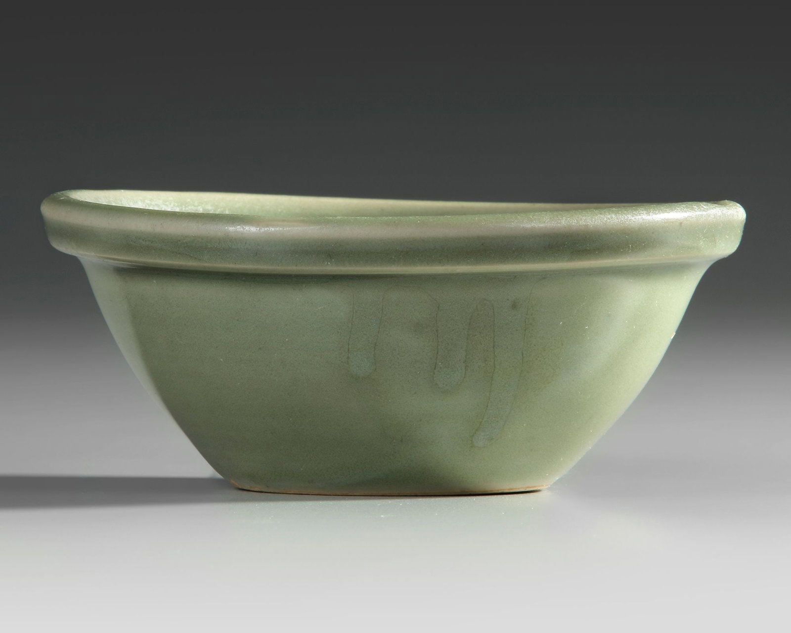 A CHINESE LONGQUAN CELADON BOWL MING DYNASTY (1368-1644): A Chinese celadon bowl, thickly potted with a narrow rounded uncovered foot, covered allover with a longquan celadon glaze. Height: 5 cm. Diameter: 14 cm. Good condition