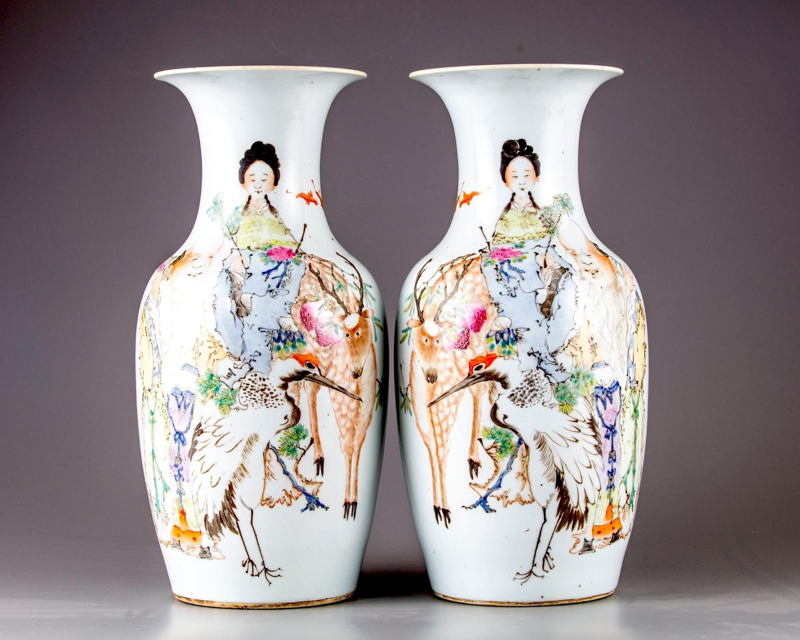 A PAIR OF CHINESE FAMILLE ROSE VASES, 19TH-20TH CENTURY: Both vases are decorated with the deity Magu, a deer, Shou Xing and a crane with two fu bats. The reverse side with Chinese calligraphy. Height 42.5 cm.