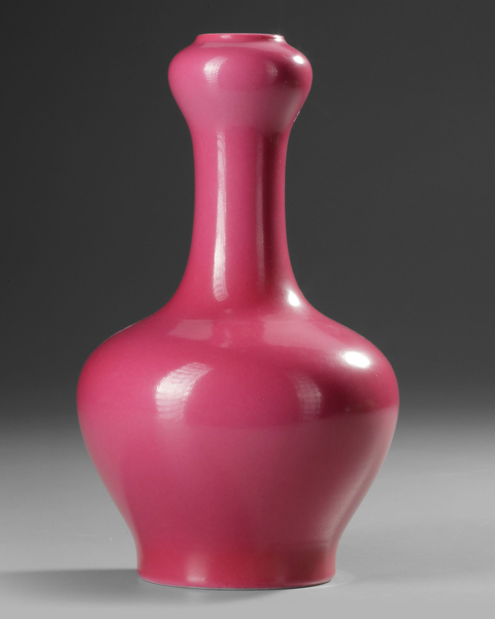 A CHINESE MONOCHROME GARLIC-HEAD VASE, 20TH CENTURY: A Chinese porcelain vase with tapering sides rising to a steep shoulder and a garlic head, covered with a pink glaze. The bottom with a Chinese Yongzheng six character mark within a double circle. Hei