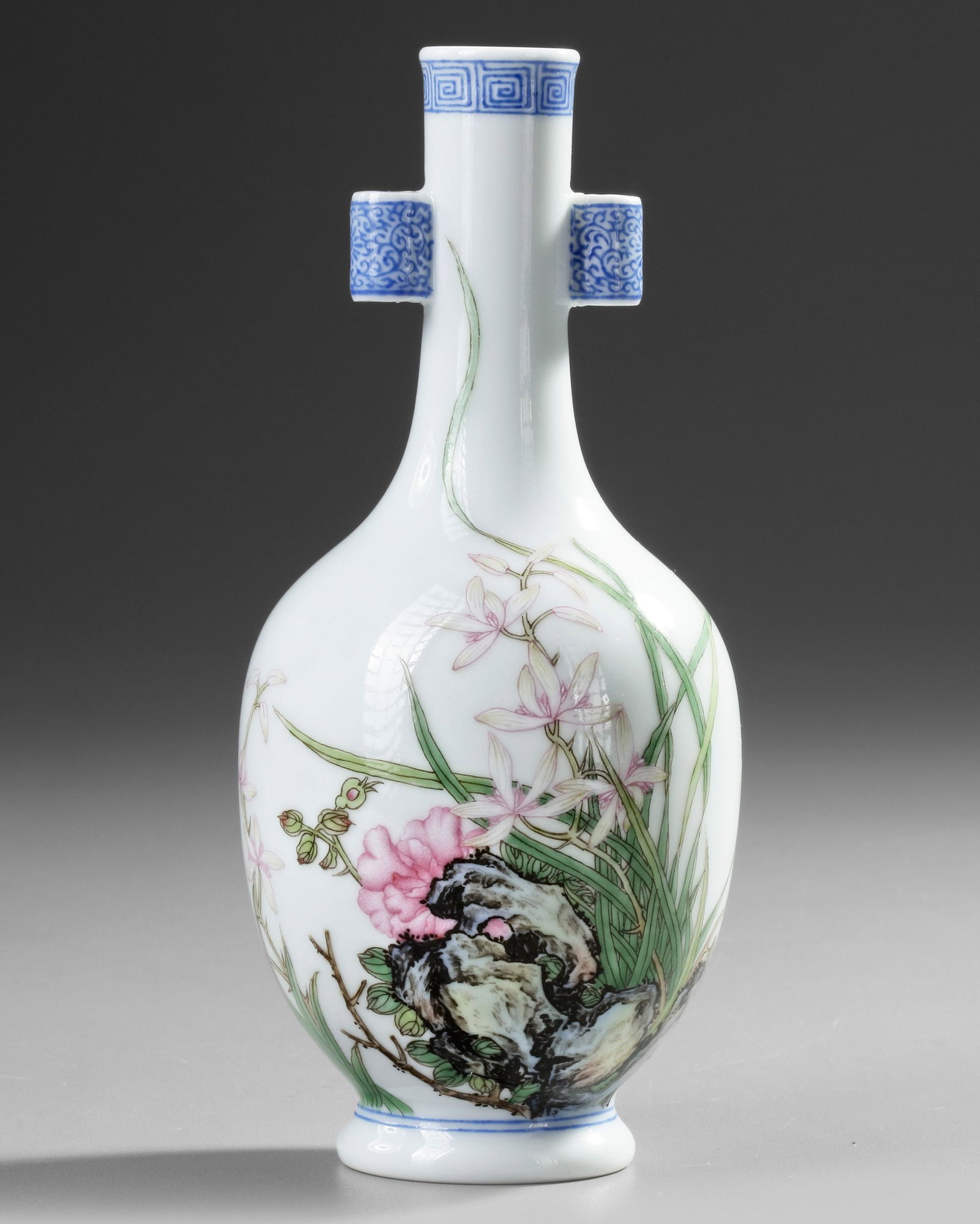 A SMALL CHINESE FAMILLE ROSE VASE, 20TH CENTURY: A Chinese porcelain bottle vase with two tubular handles, decorated with lotus and lilies growing from ornamental rocks. The backside features Chinese inscriptions, and the bottom bears a Chinese Qian
