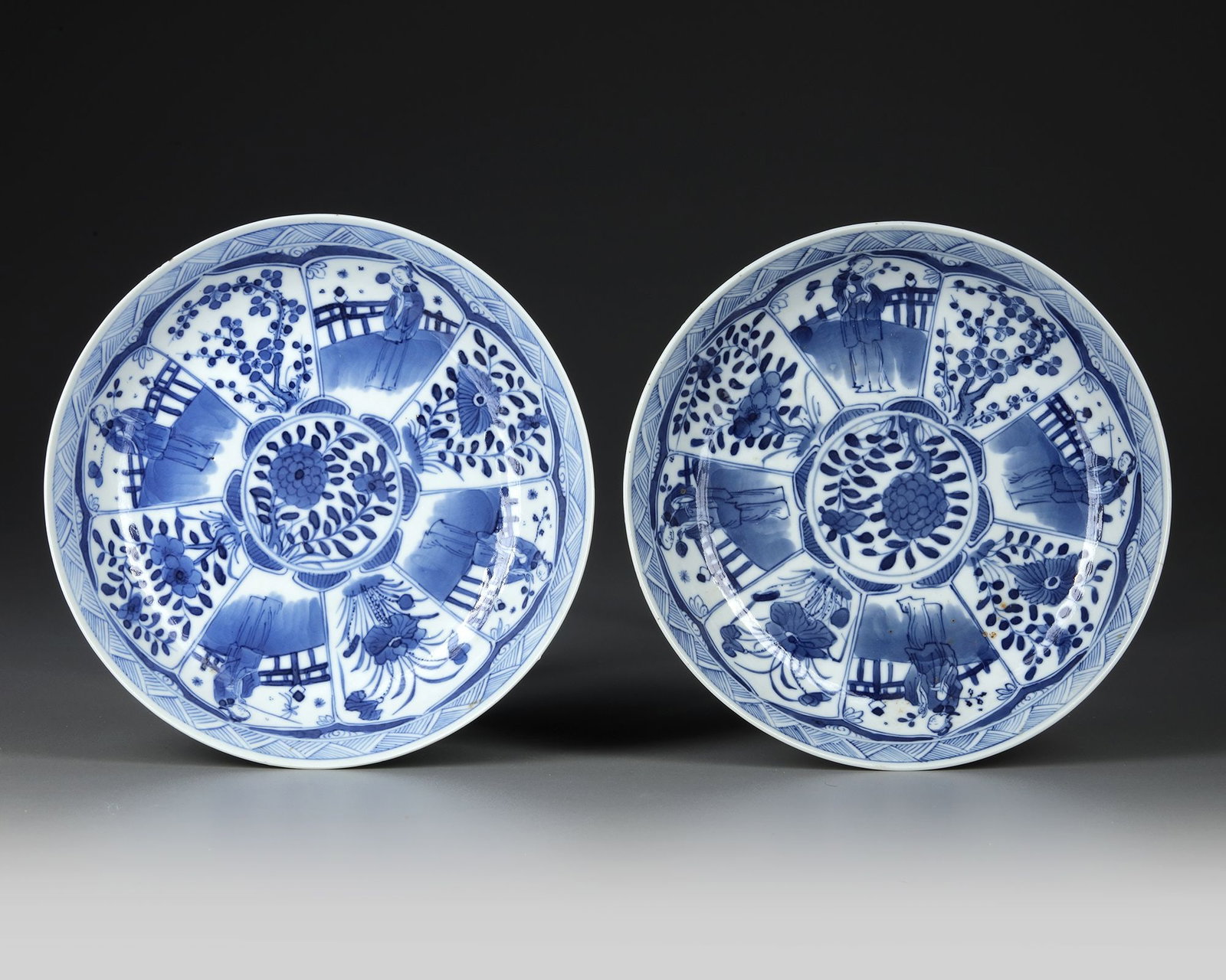 TWO CHINESE BLUE AND WHITE DISHES, 19TH CENTURY: Two dishes decorated with panels enclosing a lady holding a flower and a flowering tree. Diameter: 20 cm.