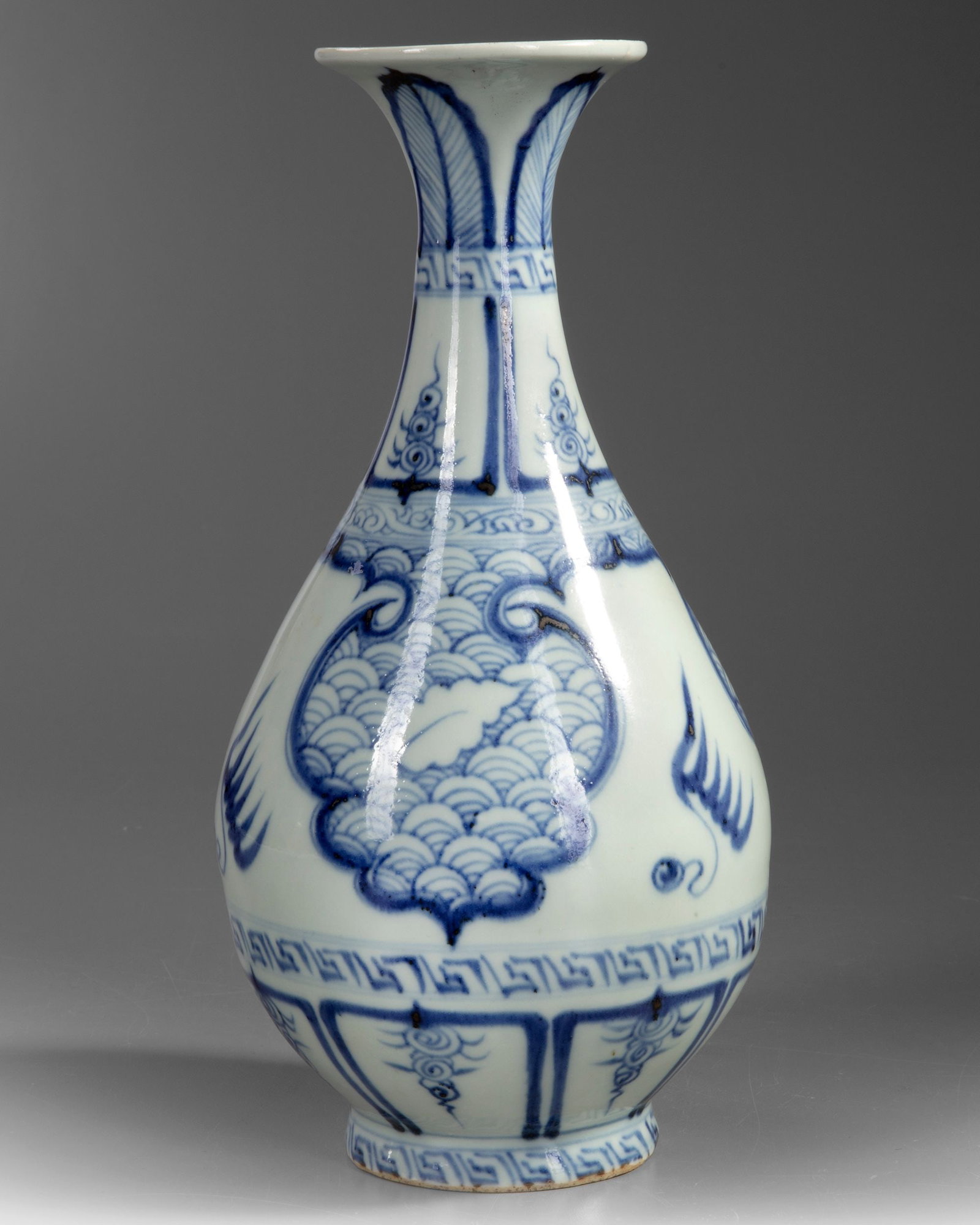 A CHINESE BLUE AND WHITE VASE, QING DYNASTY (1644â€“1911): The full, pear-shaped body is raised on a short, slightly spreading foot, rising to a slender neck with a widely everted trumpet mouth. It is freely painted in vivid tones of cobalt blue, featuring a 