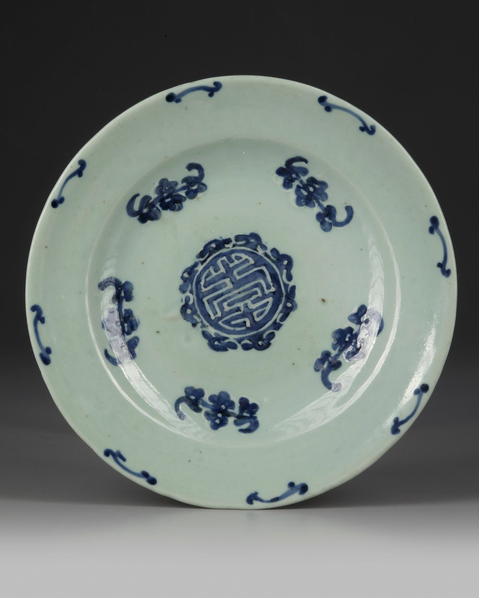 A CHINESE â€?WU FU PENG SHOUâ€™ CELADON-GROUND DISH, 19TH CENTURY: A Chinese celadon-ground dish, decorated in underglaze blue with a Shou character and Fu bats. The base bears a four-character Chenghua mark. Diameter: 28.5 cm.