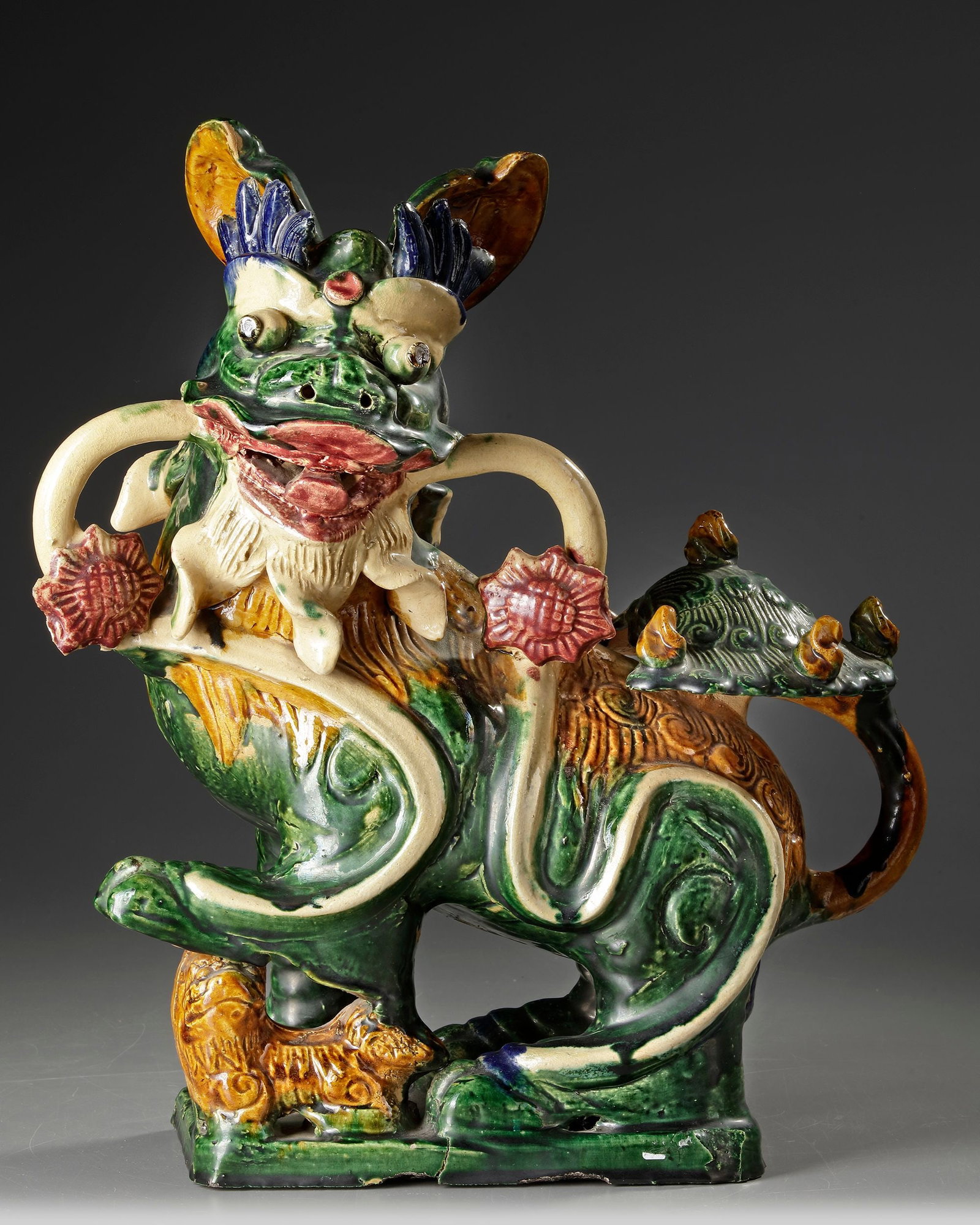 A SANCAI GLAZED FU DOG, CHINA, 20TH CENTURY: 45 by 35 by 15 cm.