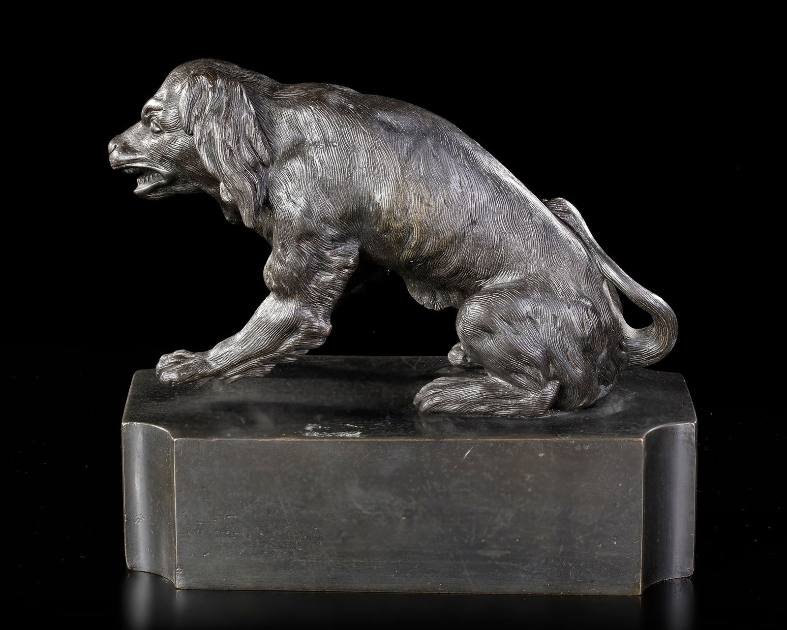 A BRONZE SCULPTURE OF A DOG, GERMANY/ITALY, LATE 18TH CENTURY: On a stone base: 23 by 11 by 6,5 cm. Height including dog: 20 cm.