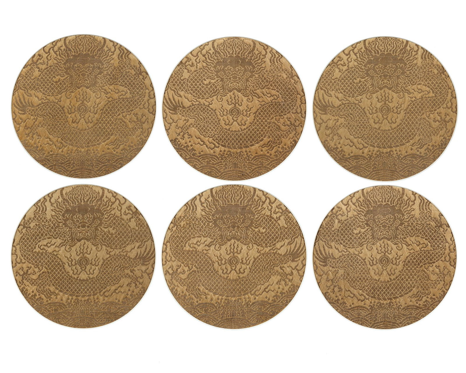 SIX TIBETAN YELLOW-GROUND BROCADE 'DRAGON' PANELS, 18TH CENTURY: Each of the roundels is woven to depict a front-facing five-clawed dragon chasing the flaming pearl amongst flame scrolls above waves crashing on rocks. Framed and glazed. The roundels diameter 23 cm.