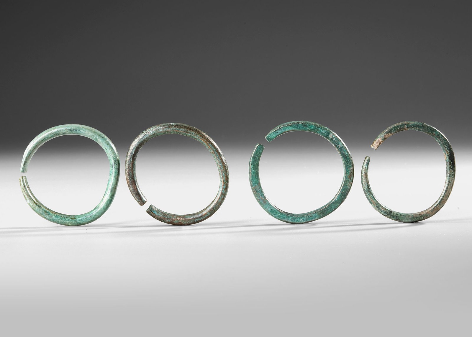FOUR BRONZE BRACELETS, BRONZE AGE, 7TH CENTURY BC: Diameter ranging between 8 and 9 cm.
