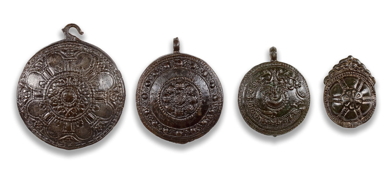 A GROUP OF FOUR BRONZE BYZANTINE BELT HOOKS: Diameter: 9.2 cm., 7.5 cm., 6.3 cm., 6.1 cm.