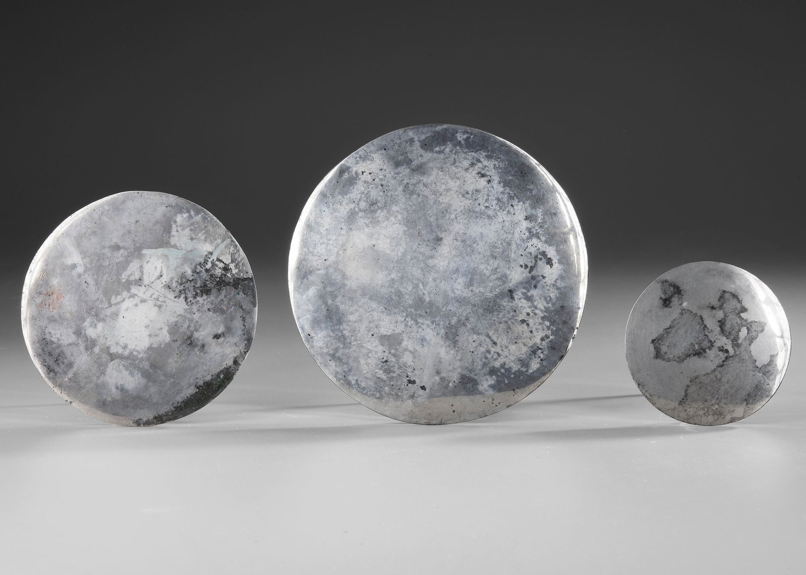 THREE ROMAN SILVER MIRRORS, 1ST - 2ND CENTURY AD: Diameter 15, 12 and 8 cm.