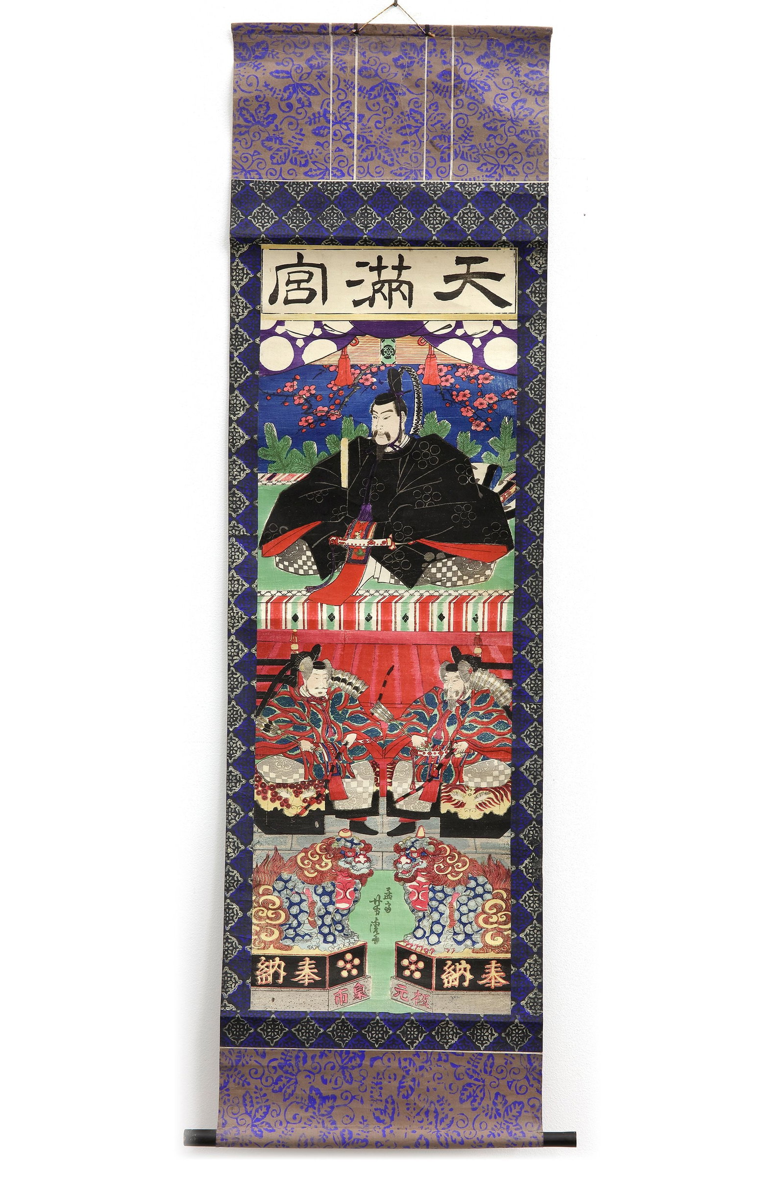 A JAPANESE HANGING SCROLL, 20TH CENTURY: A vibrant Japanese hanging scroll depicting a noble court figure seated in ceremonial attire, accompanied by attendants and guardian lion-dogs (komainu). Richly colored and highly decorative, the comp