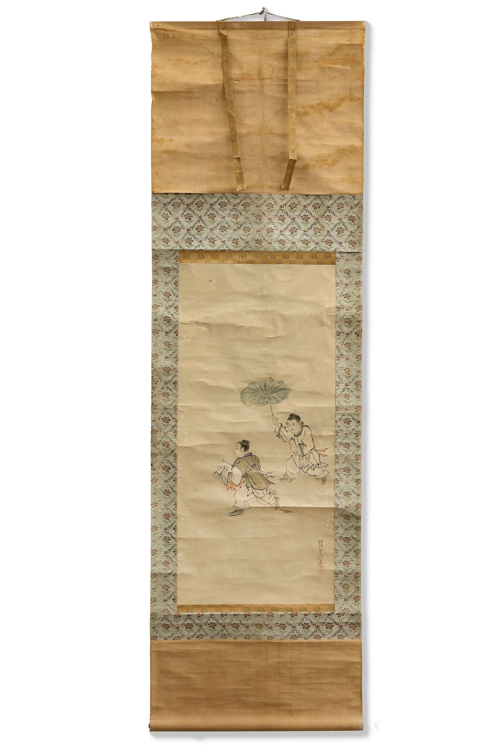 A JAPANESE HANGING SCROLL, 20TH CENTURY: A charming Japanese hanging scroll depicting two young attendants in motion, one carrying a large lotus leaf as a natural umbrella. Rendered with delicate ink lines and subtle color washes, the scene 